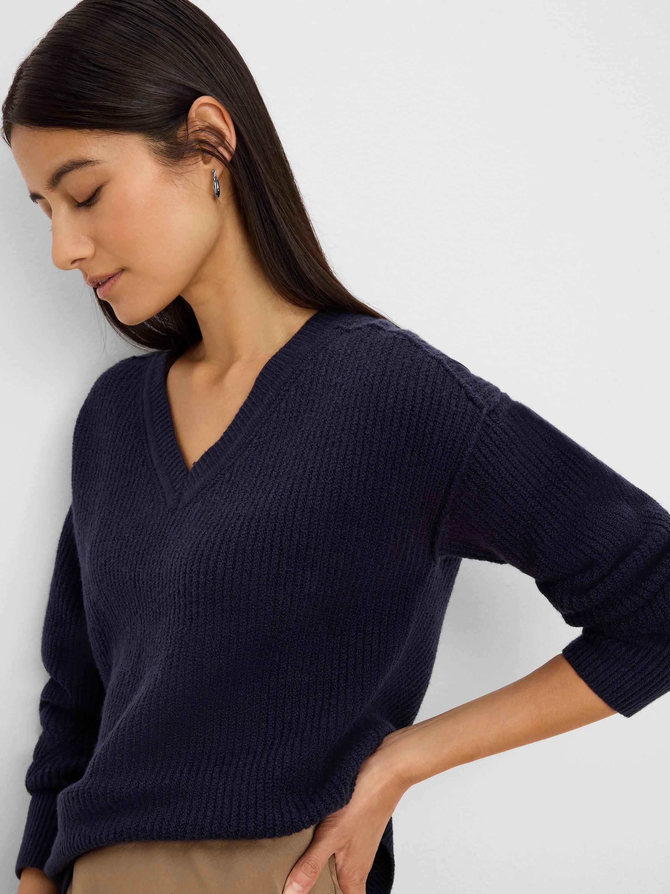 Navy V-neck sweater with a textured, ribbed knit. Features a relaxed fit on the model.