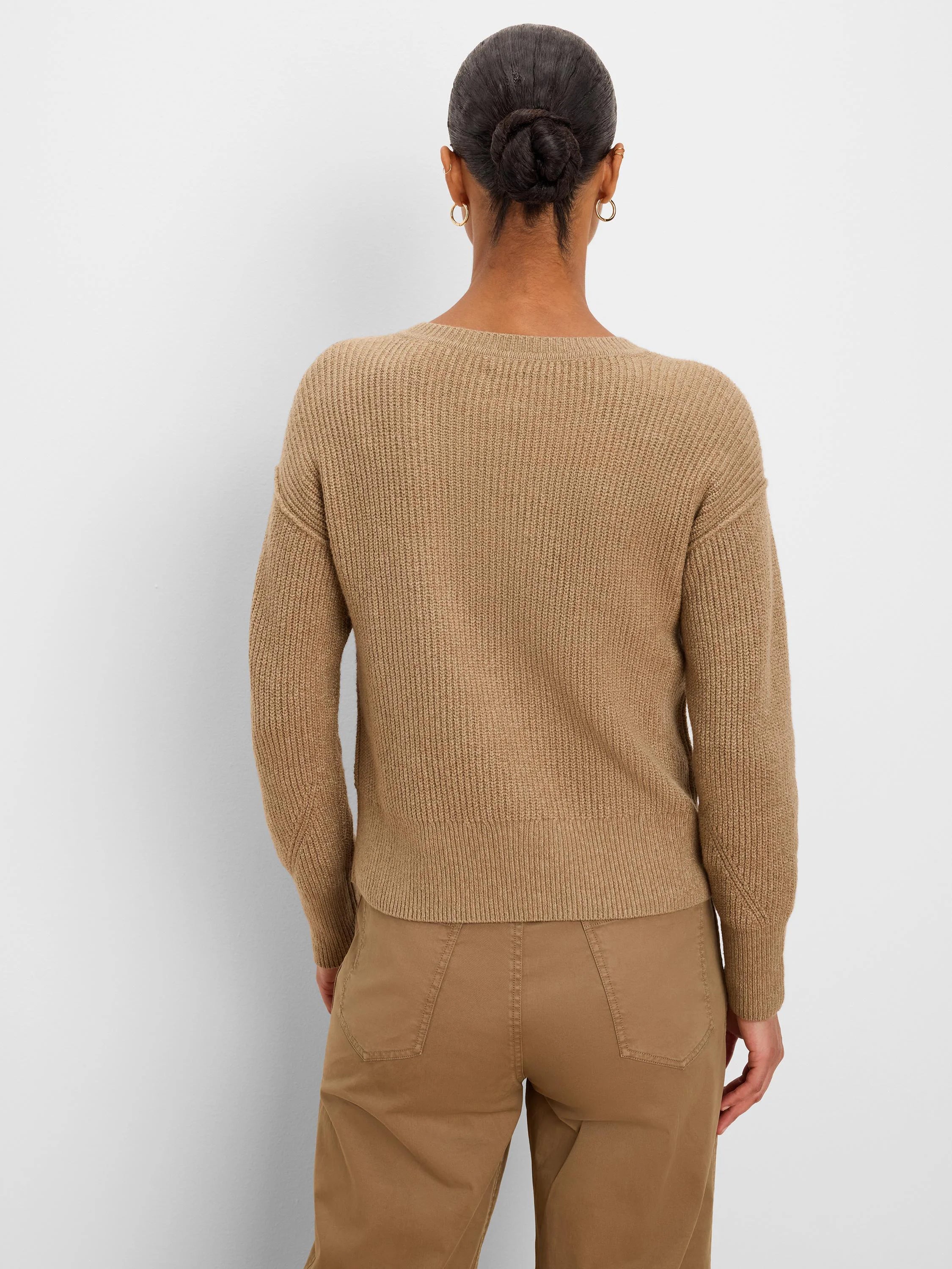Back of model wearing a tan ribbed knit sweater. Features a crewneck, long sleeves, and a ribbed hem.