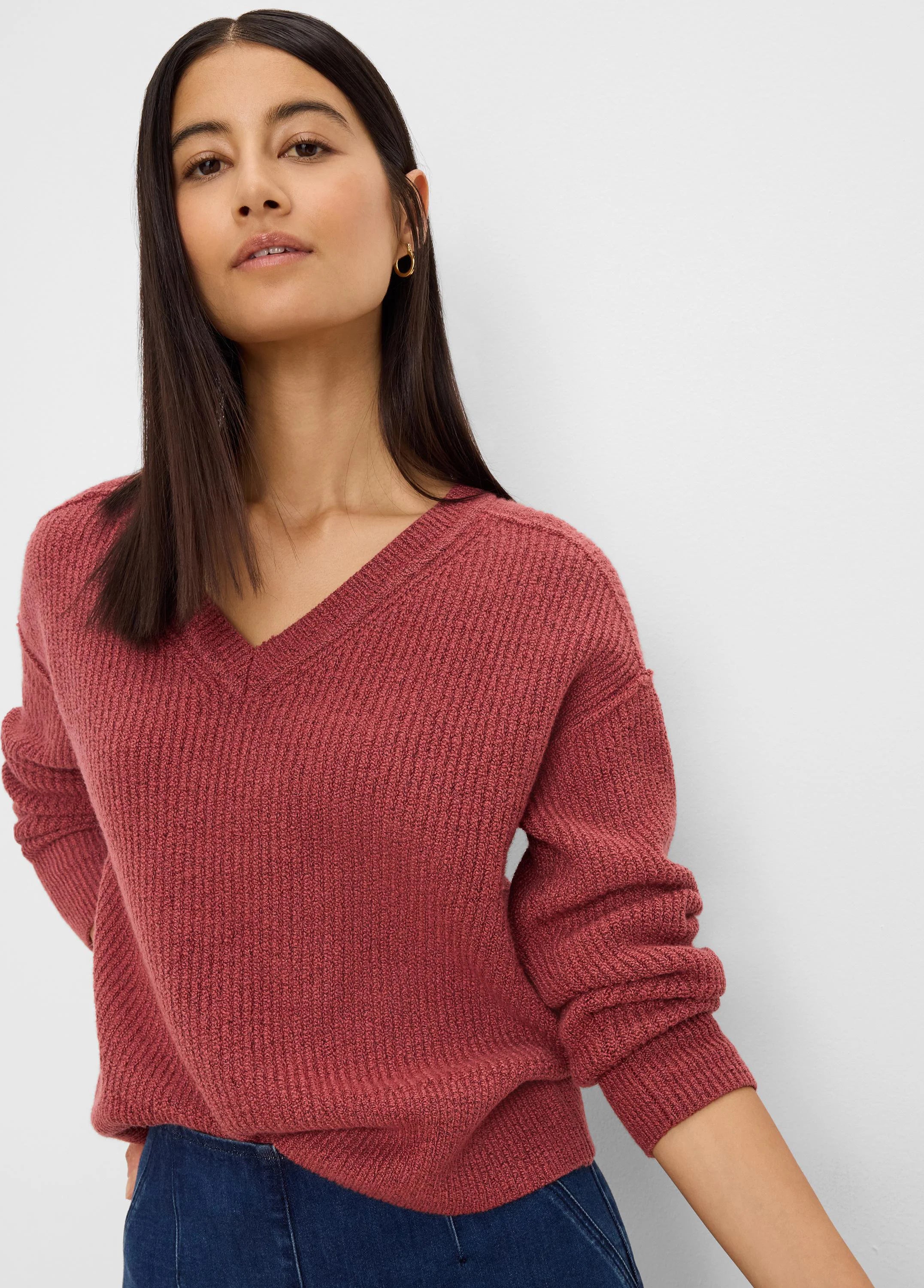 Rust-colored V-neck sweater with ribbed texture, relaxed fit, and long sleeves.
