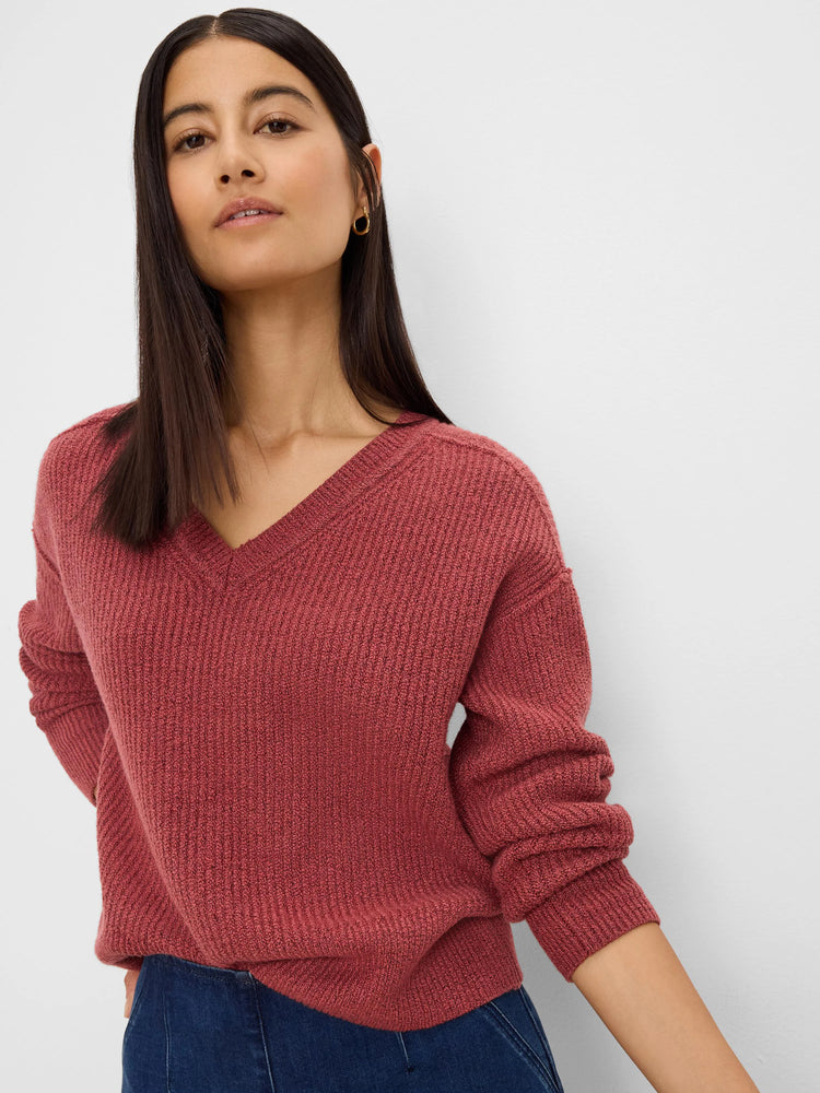 Rust-colored V-neck sweater with ribbed texture, relaxed fit, and long sleeves.