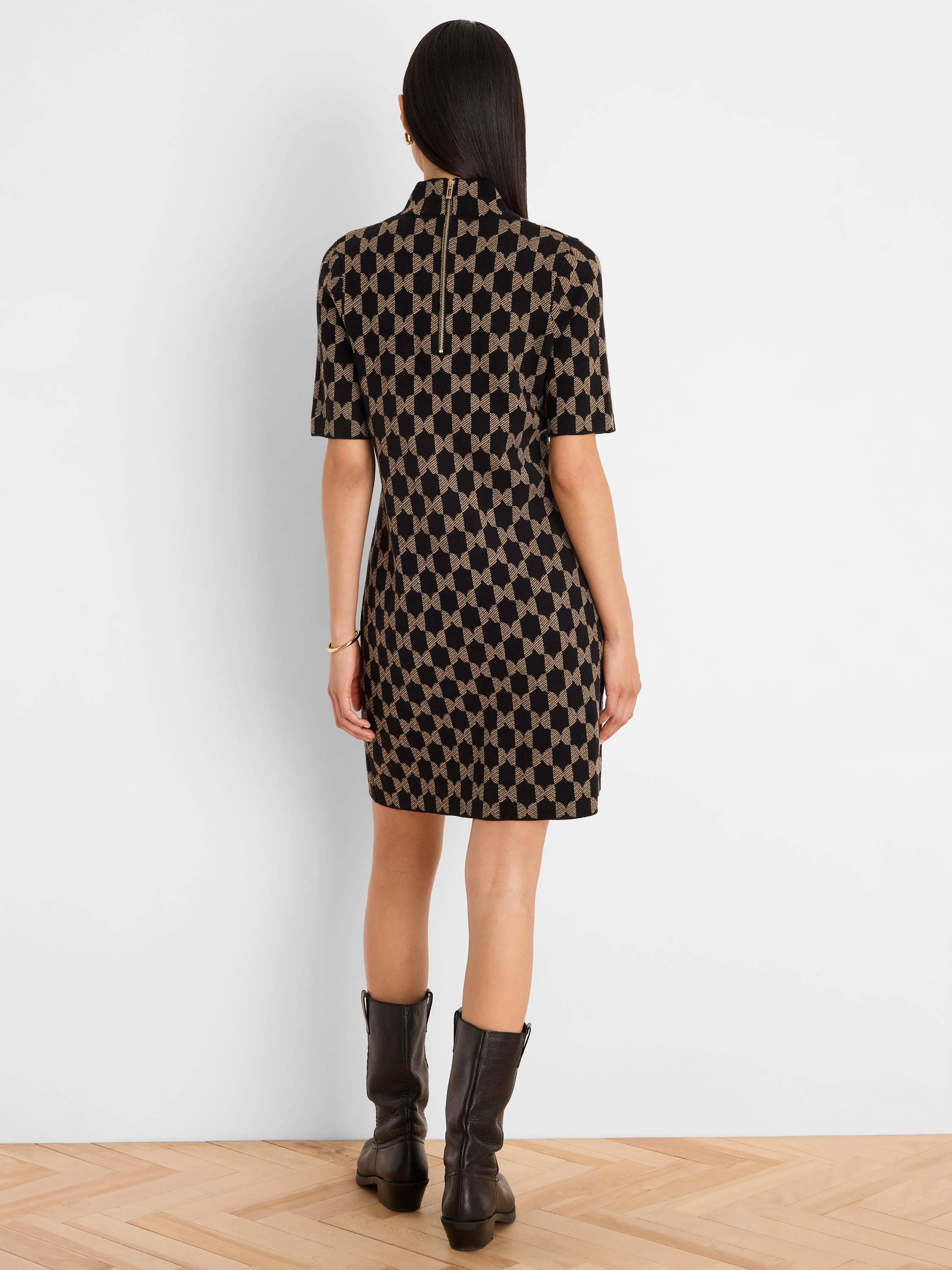Black and tan geometric knit dress, short sleeves, high neck, with a visible gold zipper down the back.