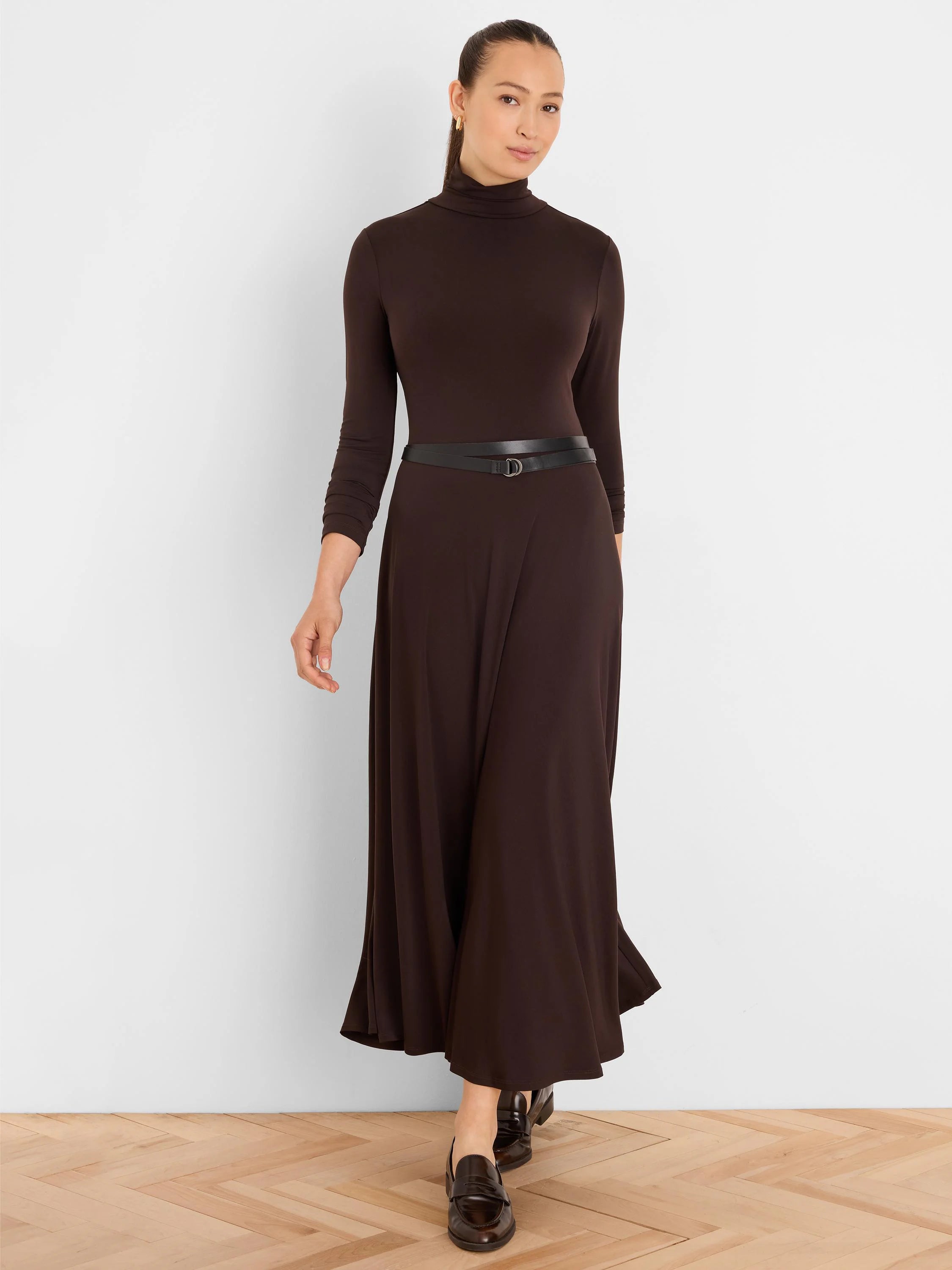 Dark brown high-neck, long-sleeve maxi dress with a flowing skirt.