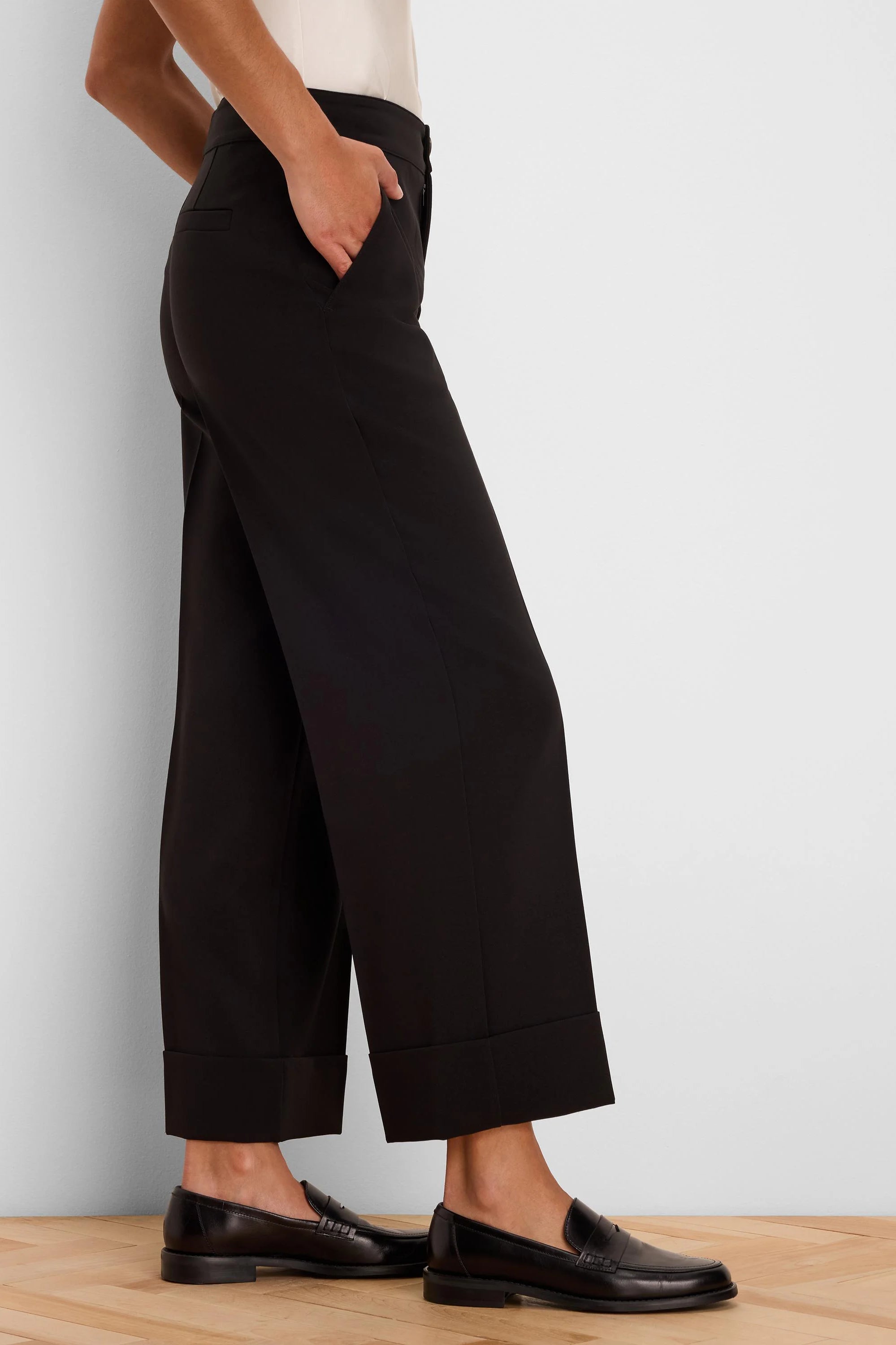 Black wide-leg ankle pants with folded cuffs, a smooth fabric, and a visible side pocket detail.
