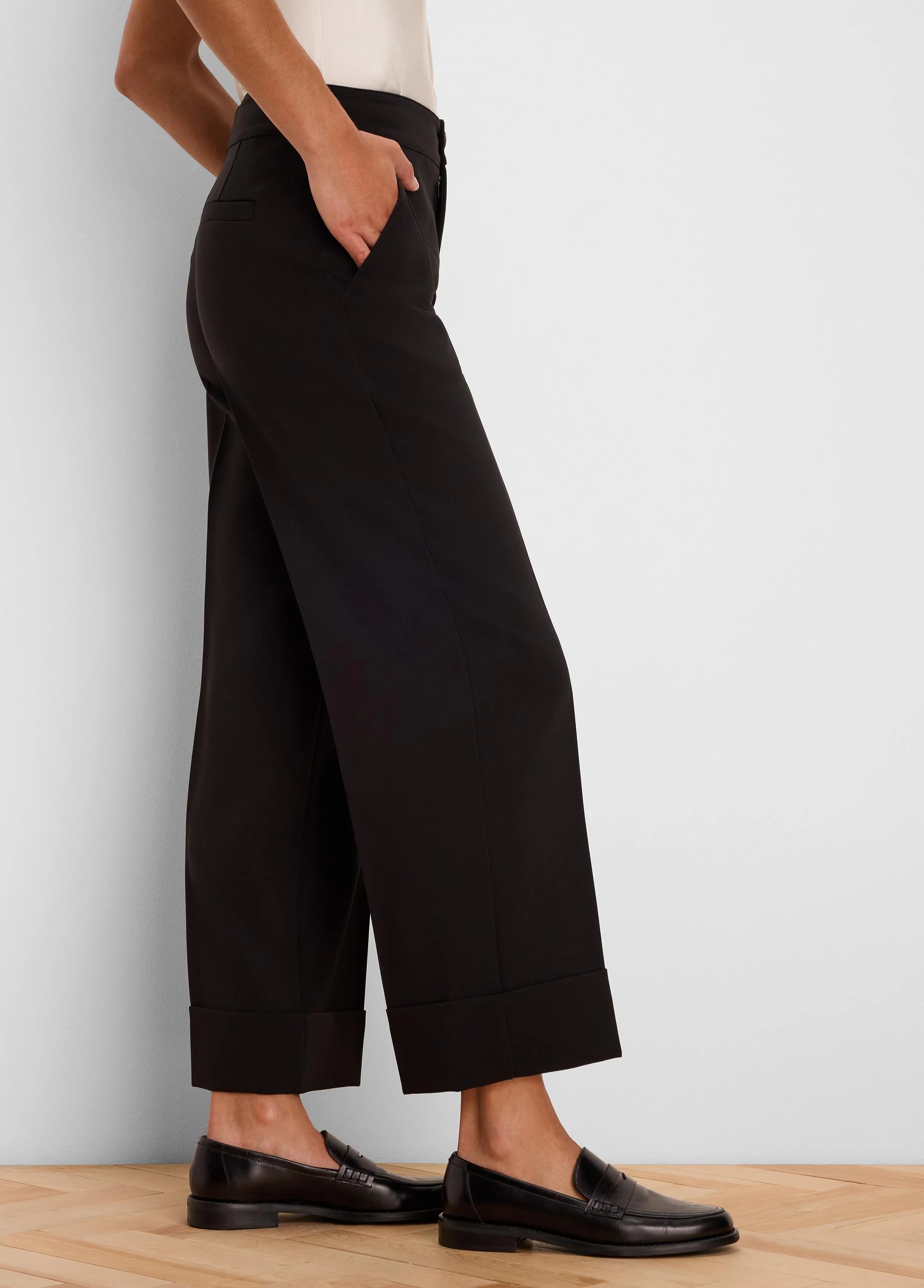 Black wide-leg ankle pants with folded cuffs, a smooth fabric, and a visible side pocket detail.