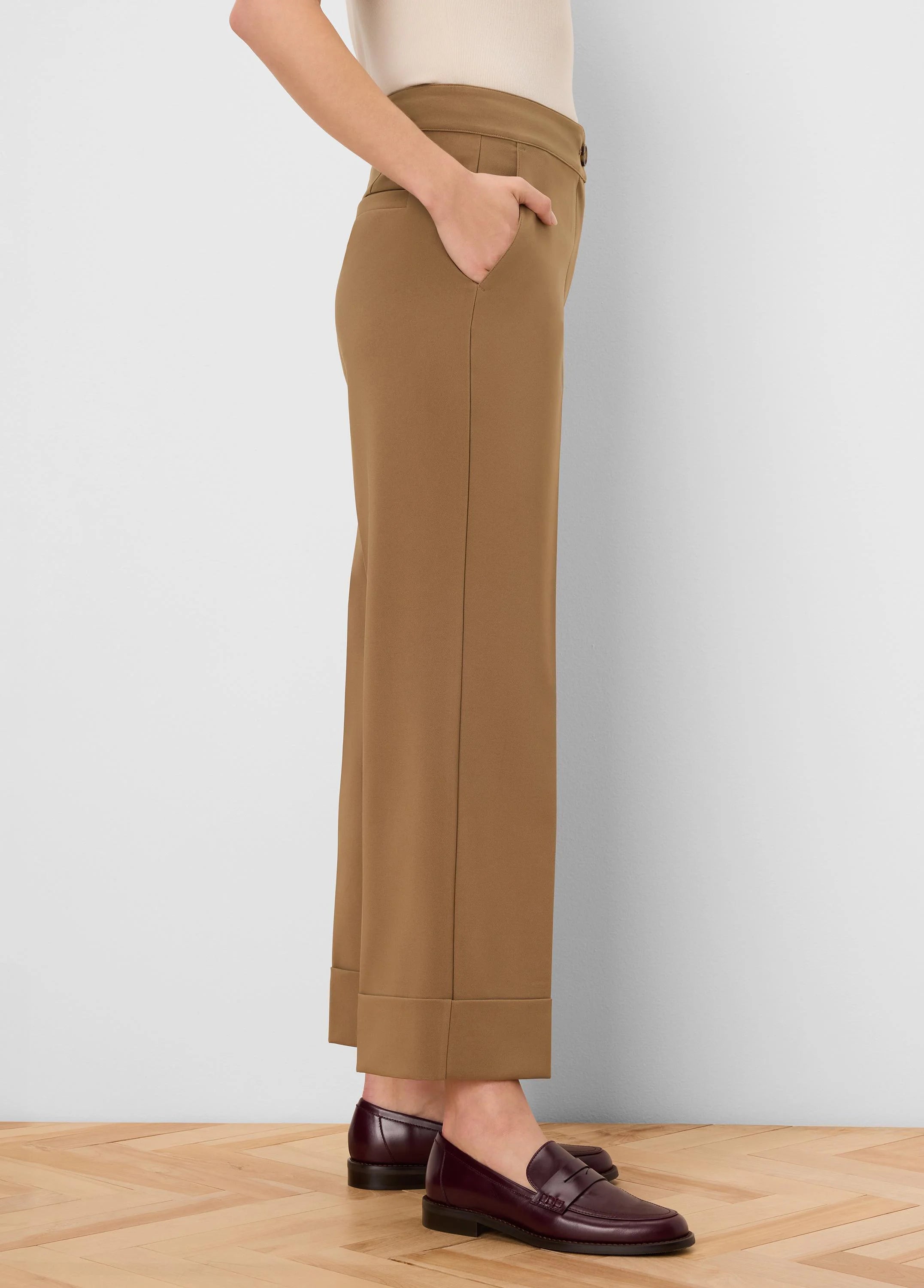 Tan sleek stretch pants with cuffed ankles and visible side pockets.