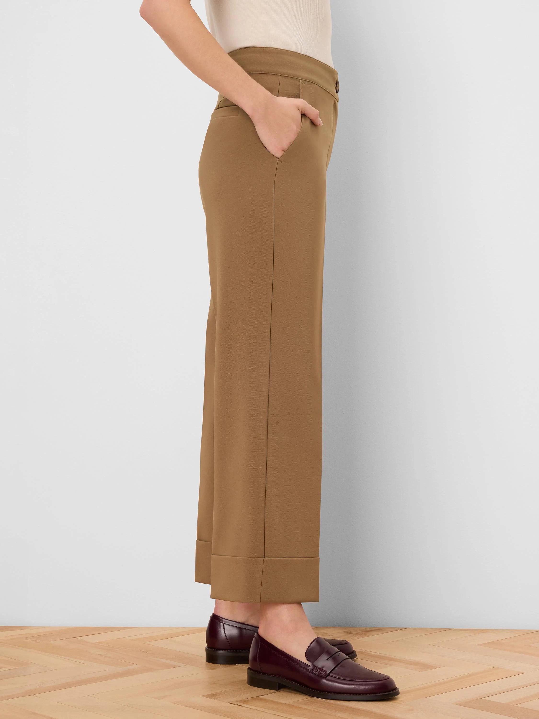 Tan sleek stretch pants with cuffed ankles and visible side pockets.