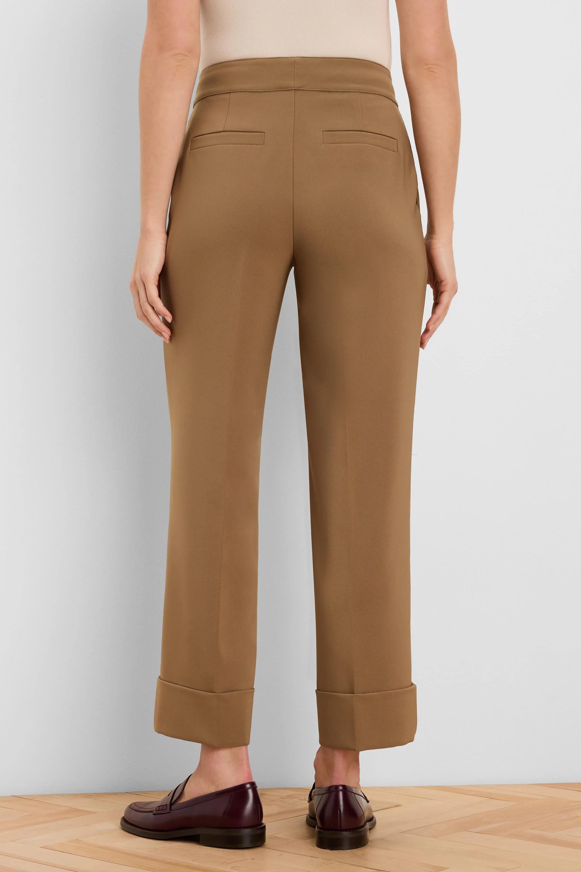 Tan cuffed ankle pants with two back welt pockets, shown from behind.