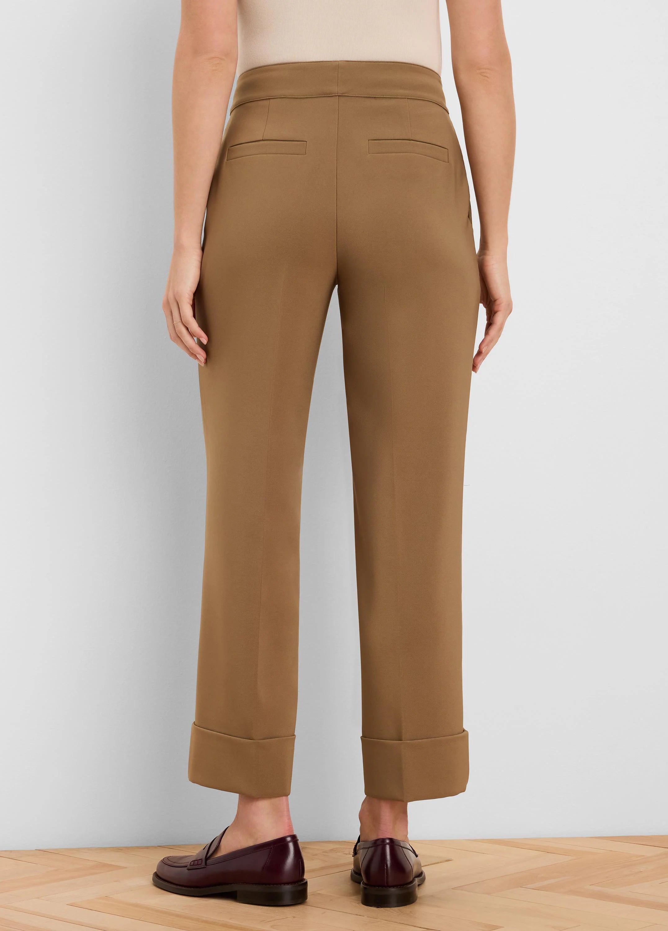 Tan cuffed ankle pants with two back welt pockets, shown from behind.