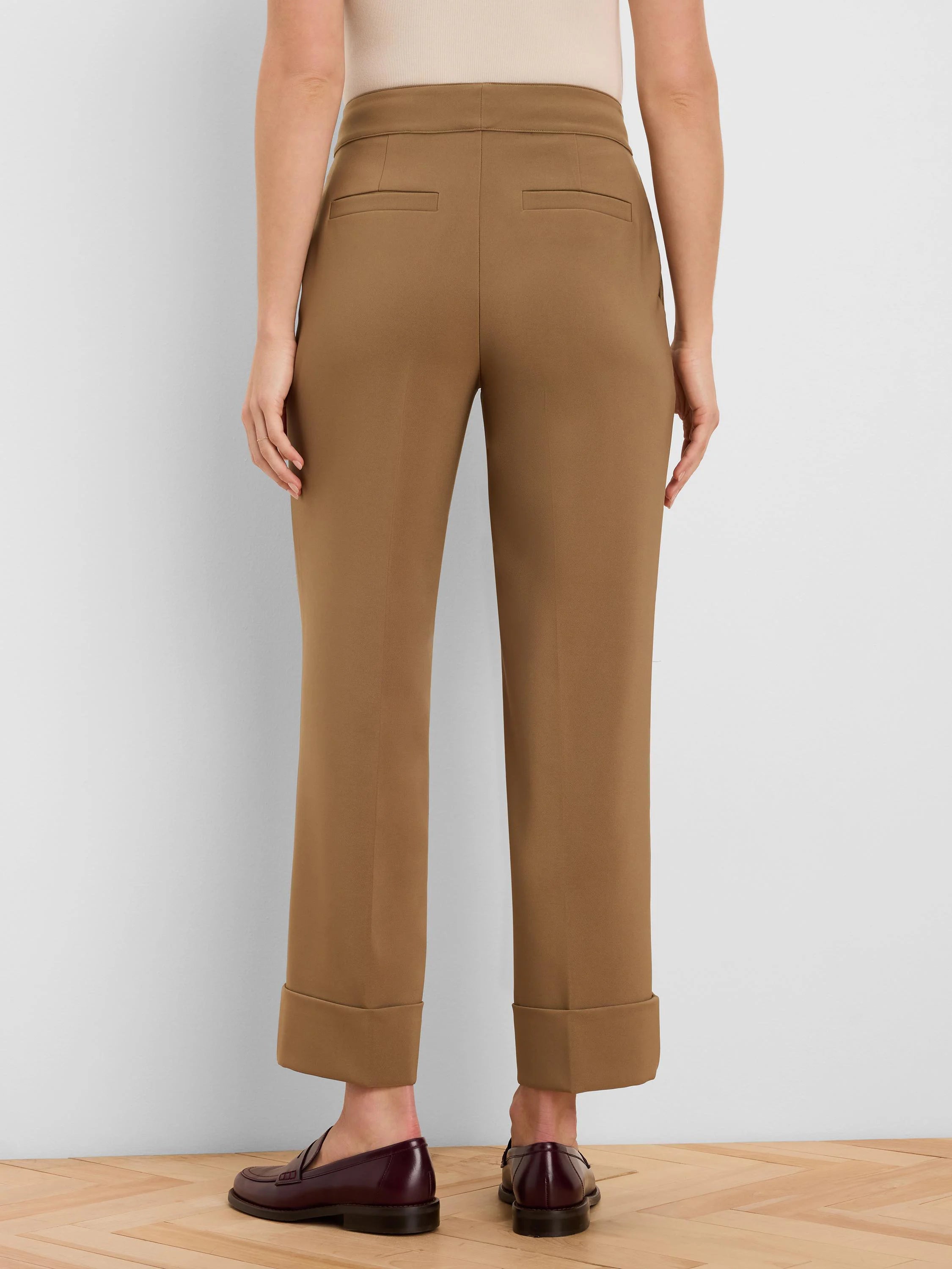 Tan cuffed ankle pants with two back welt pockets, shown from behind.