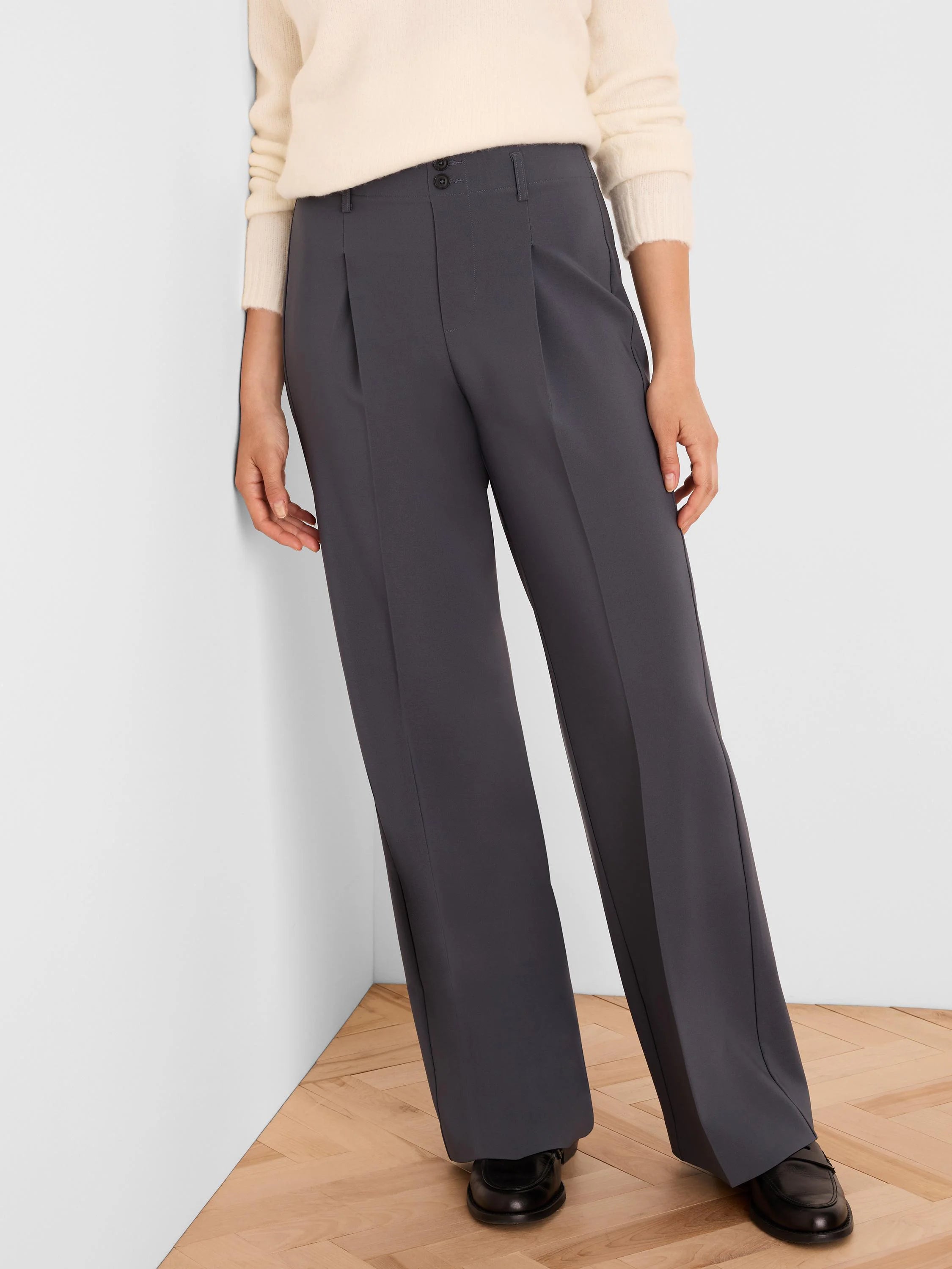 Charcoal wide-leg trousers with front pleats, two visible black buttons at the waist, and smooth fabric.