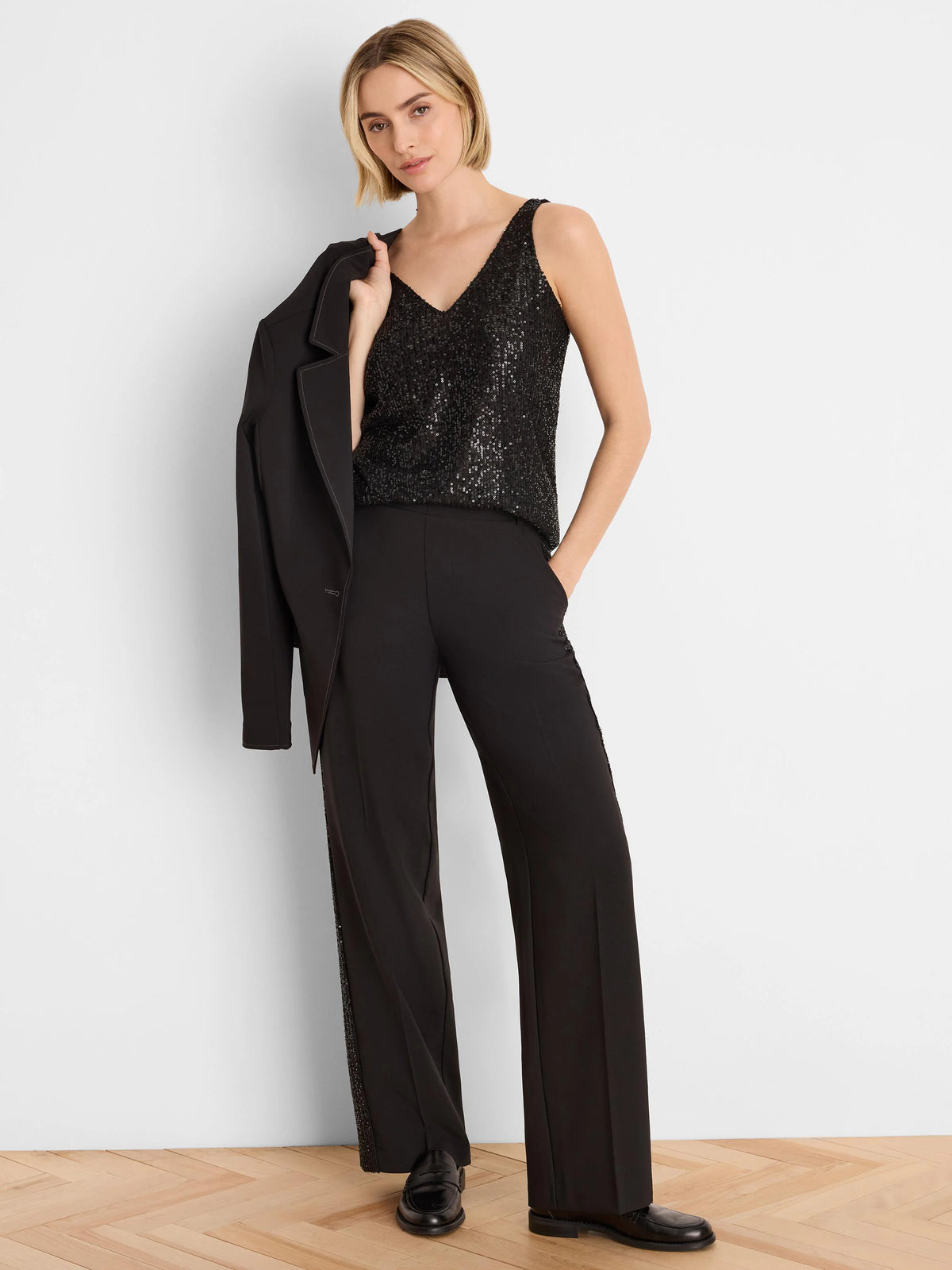 Black wide-leg tuxedo pants with a vertical sequin stripe down the outer seam, shown on a standing model.
