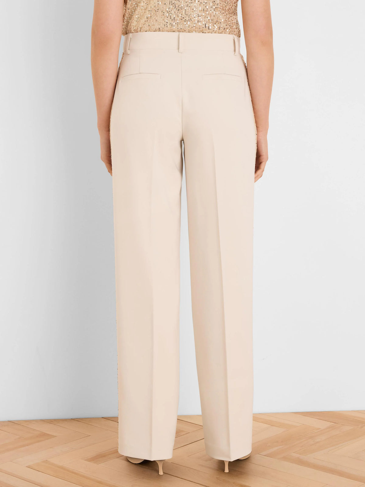 Back view of light beige wide-leg tuxedo pants with two horizontal back pockets and vertical sequin stripes.