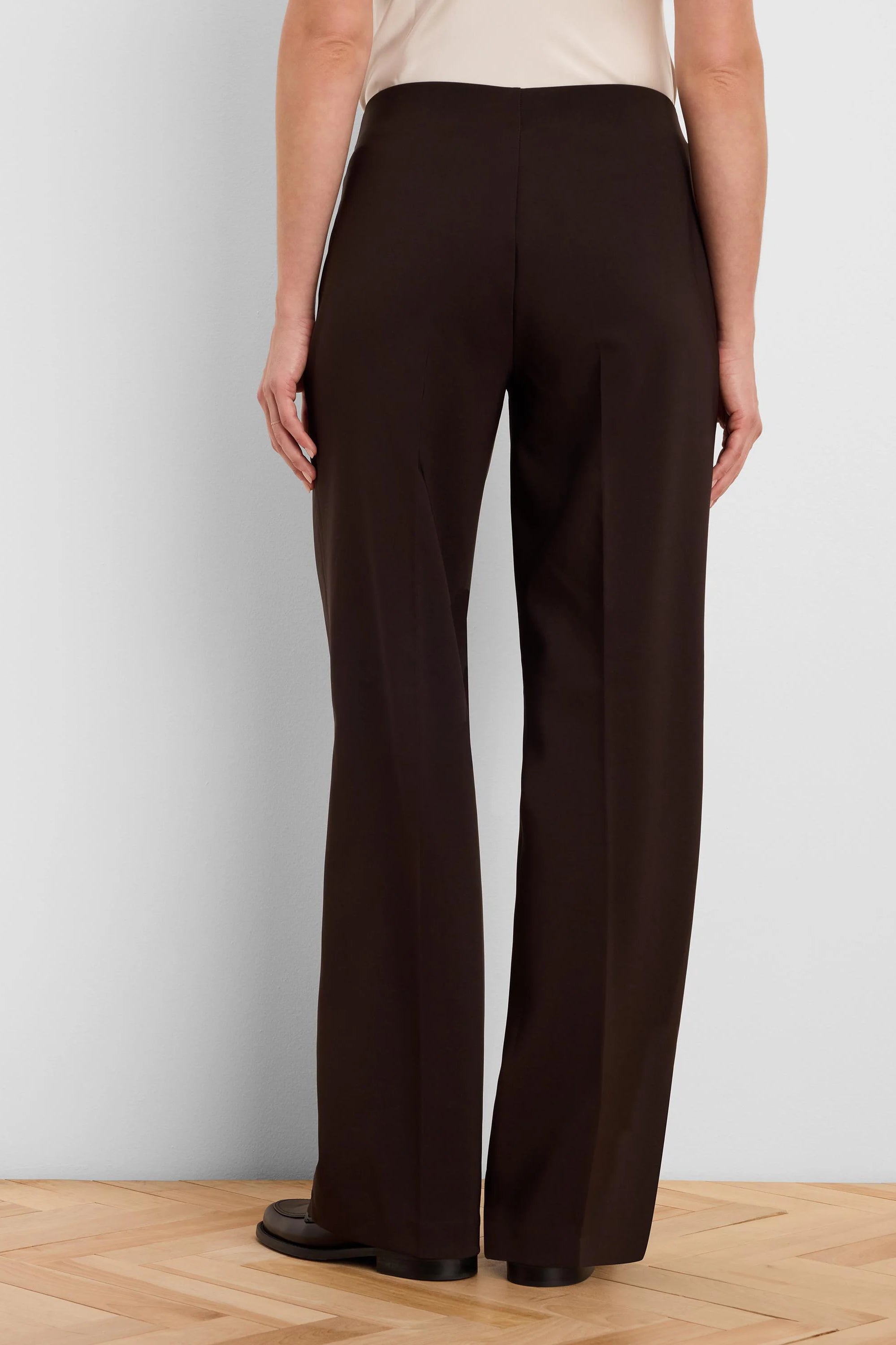 Dark brown wide-leg pants on model, back view. Smooth fabric.