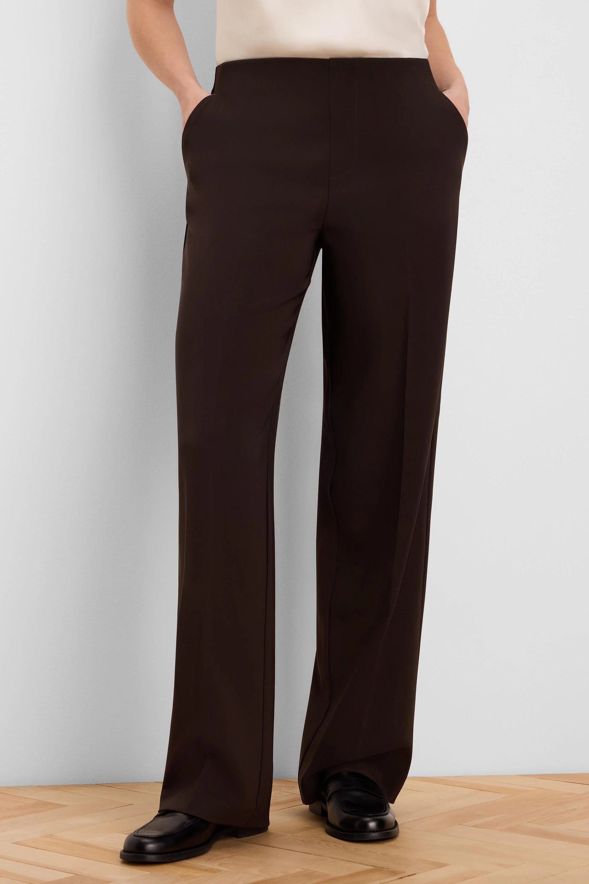 Dark brown wide-leg pants, full length. Features a smooth, flat waistband, subtle side pockets, and a clean drape.