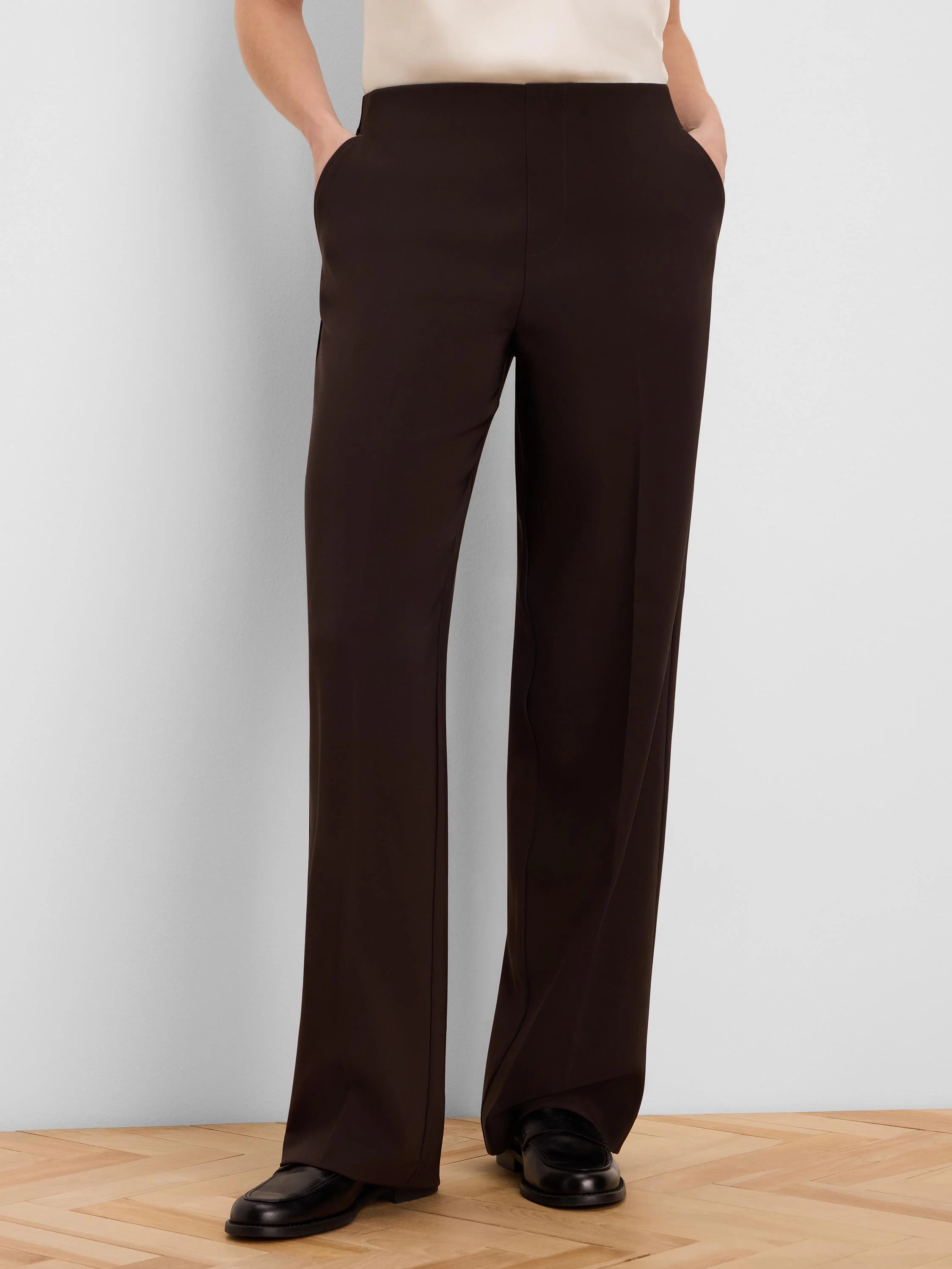 Dark brown wide-leg pants, full length. Features a smooth, flat waistband, subtle side pockets, and a clean drape.