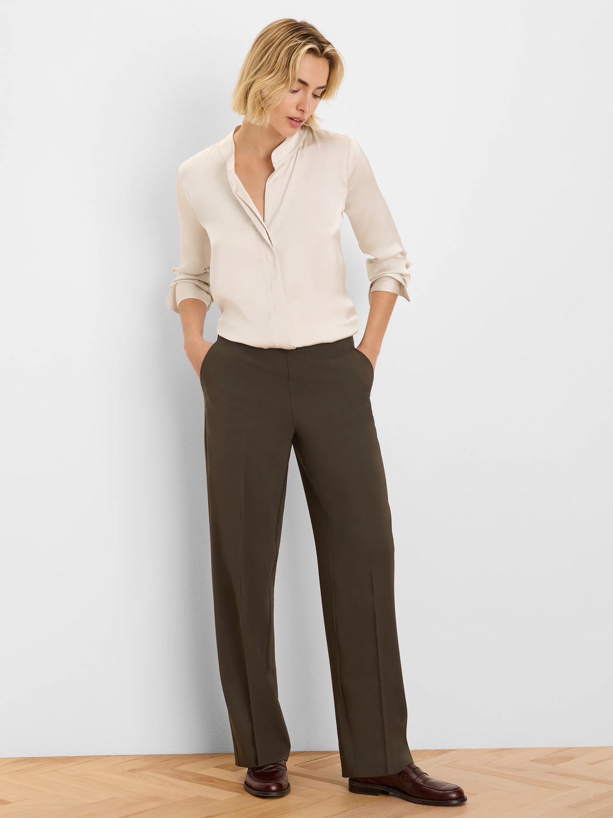Dark olive wide-leg pants with sleek fabric and pressed front creases.