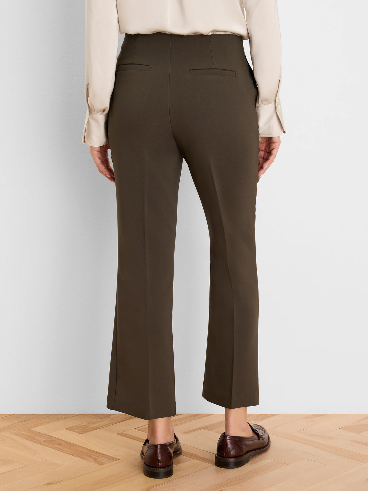 Dark olive high-waist ankle pants with a demi boot cut, seen from behind. Features two horizontal back welt pockets.