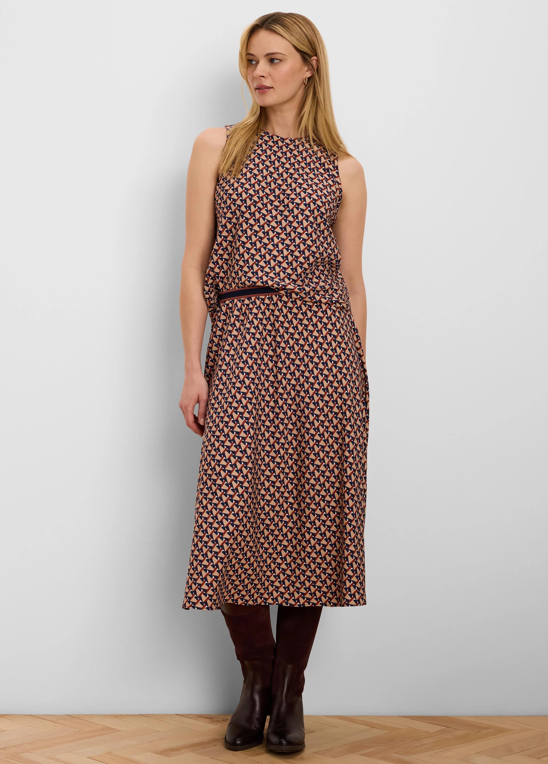 Sleeveless top with a geometric pattern of dark blue, rust, and beige interlocking shapes.