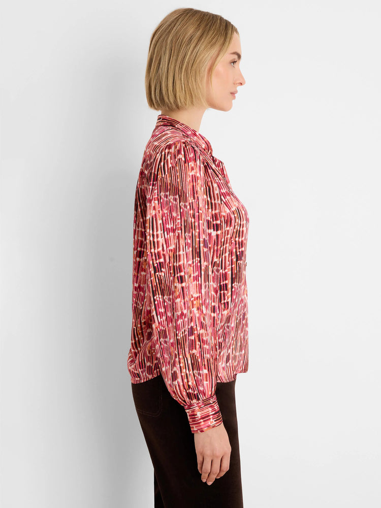 Red, orange, and dark-toned abstract vertical striped shirt with fine pleats and long cuffed sleeves.