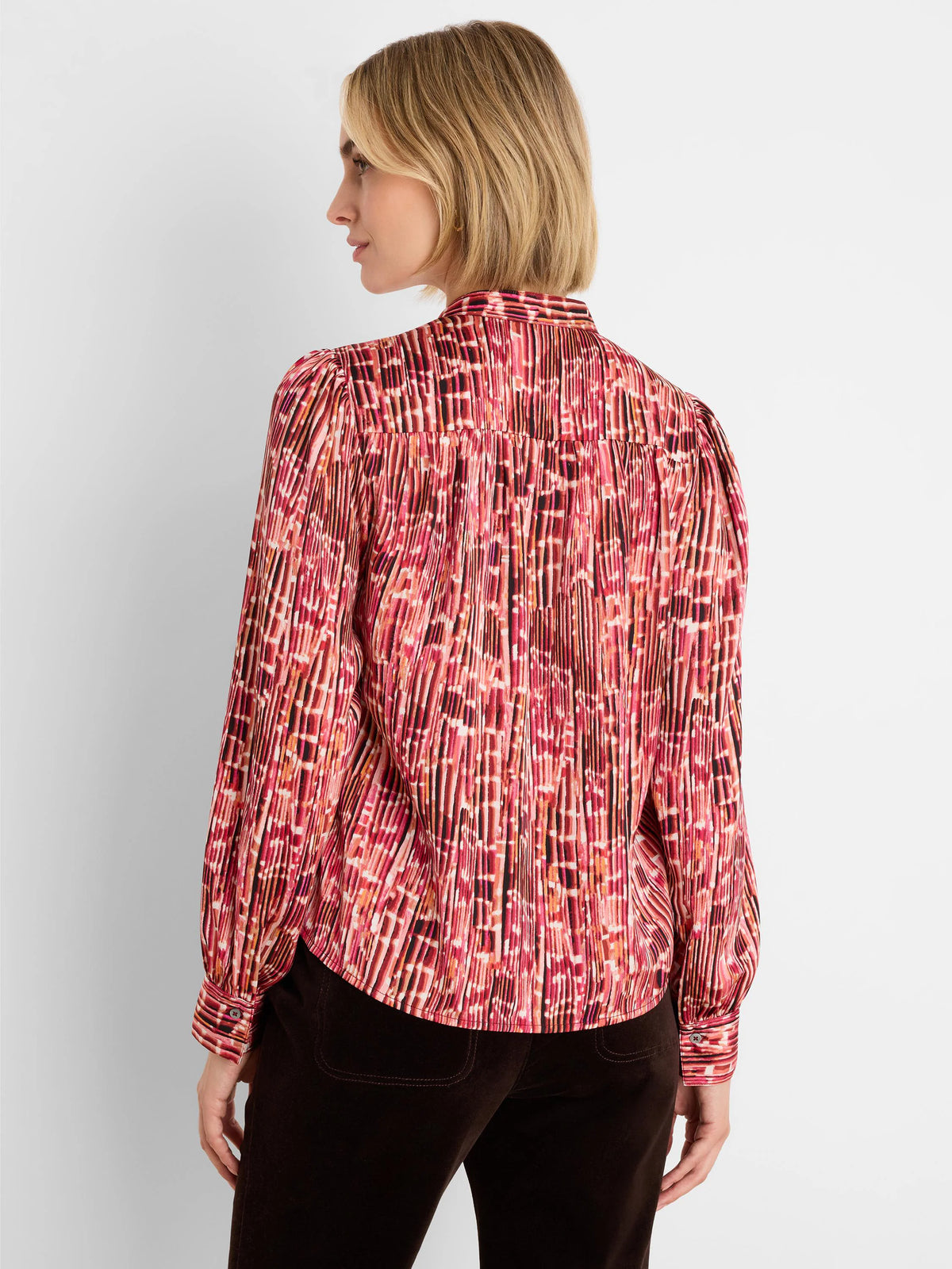 Pink, red, & black pleated shirt with abstract vertical stripe pattern, puffed sleeves, and buttoned cuffs.