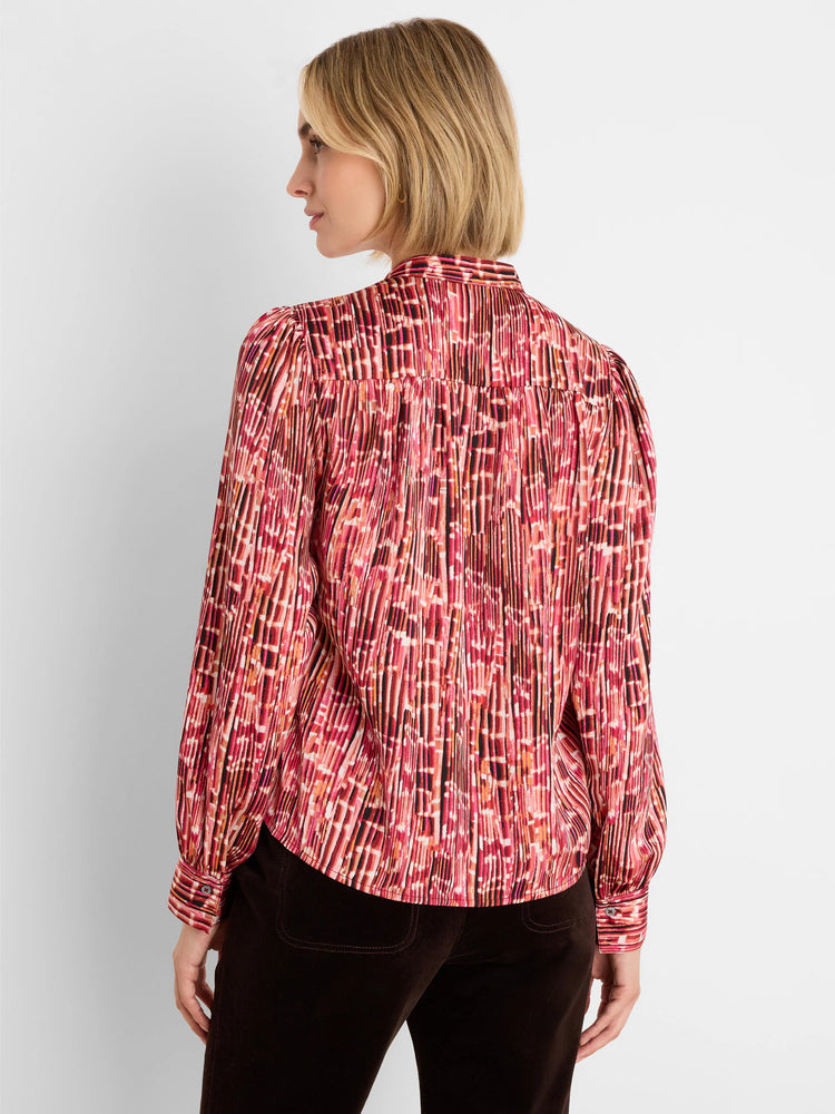 Pink, red, & black pleated shirt with abstract vertical stripe pattern, puffed sleeves, and buttoned cuffs.