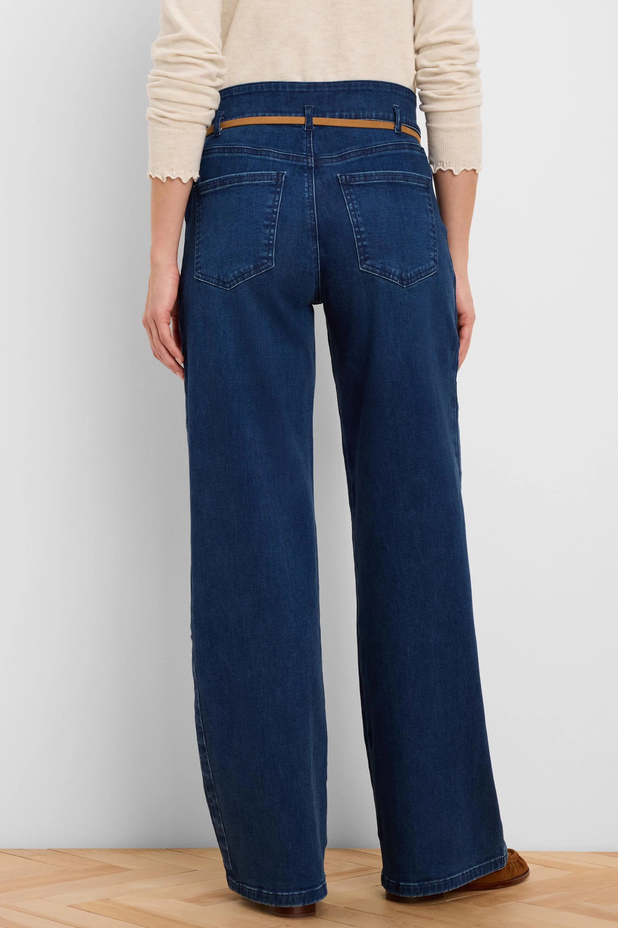 Dark blue wide-leg jeans with a thin brown belt, viewed from behind. Features high waist and back pockets.