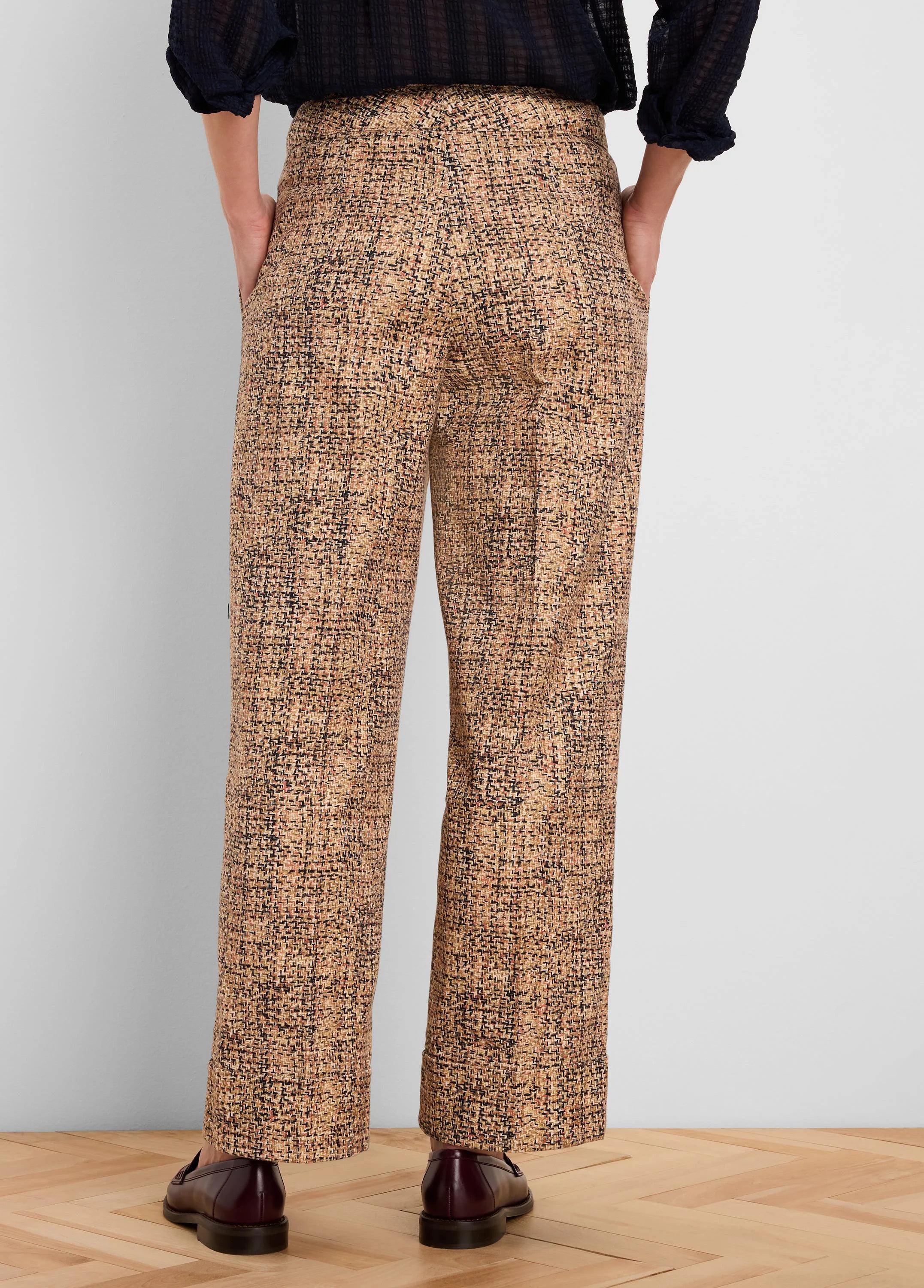 Tweed ankle pants with cuffed hems, patterned in tan, black, and rust flecks, shown from the back.