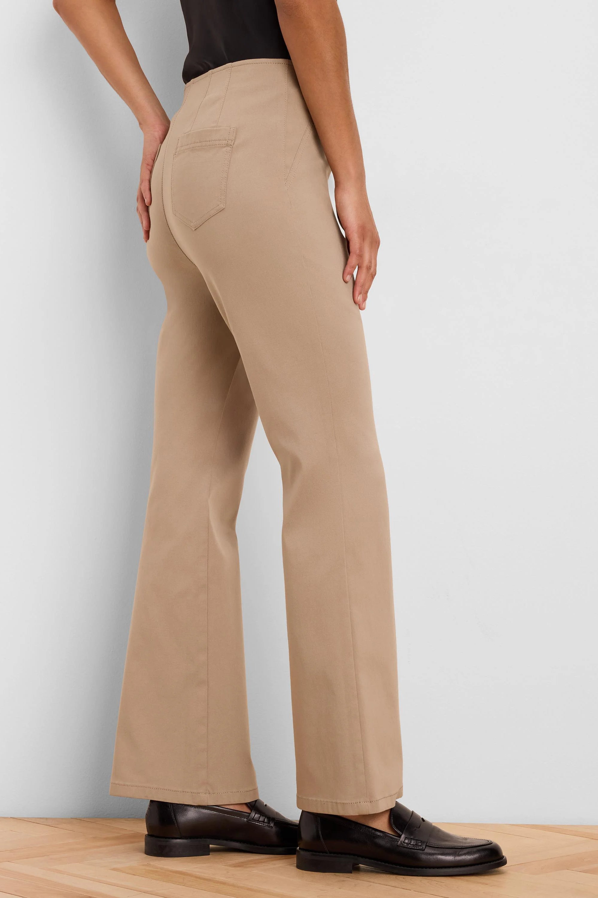 Tan high-waisted bootcut pants with back pockets, shown from behind on a model.