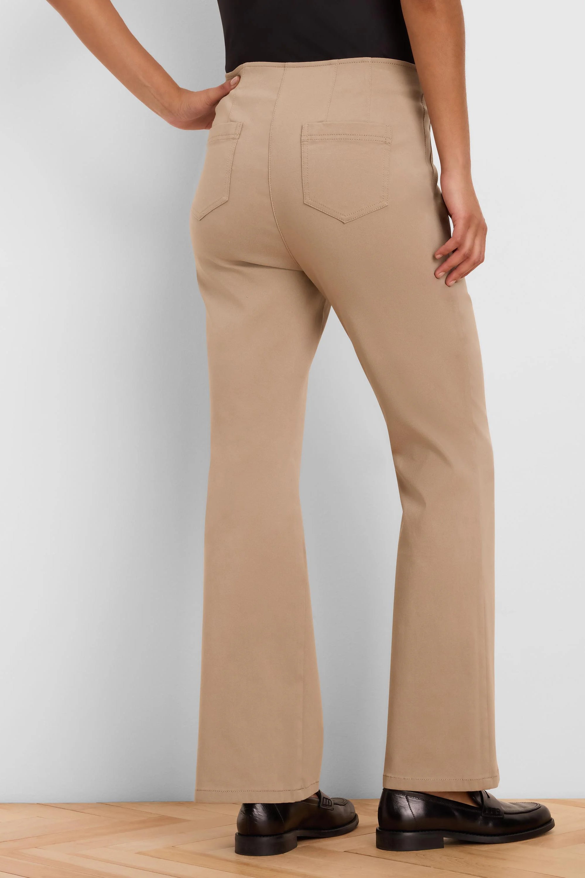 Tan bootcut pants, high-waisted with rear patch pockets, shown from behind on a model.