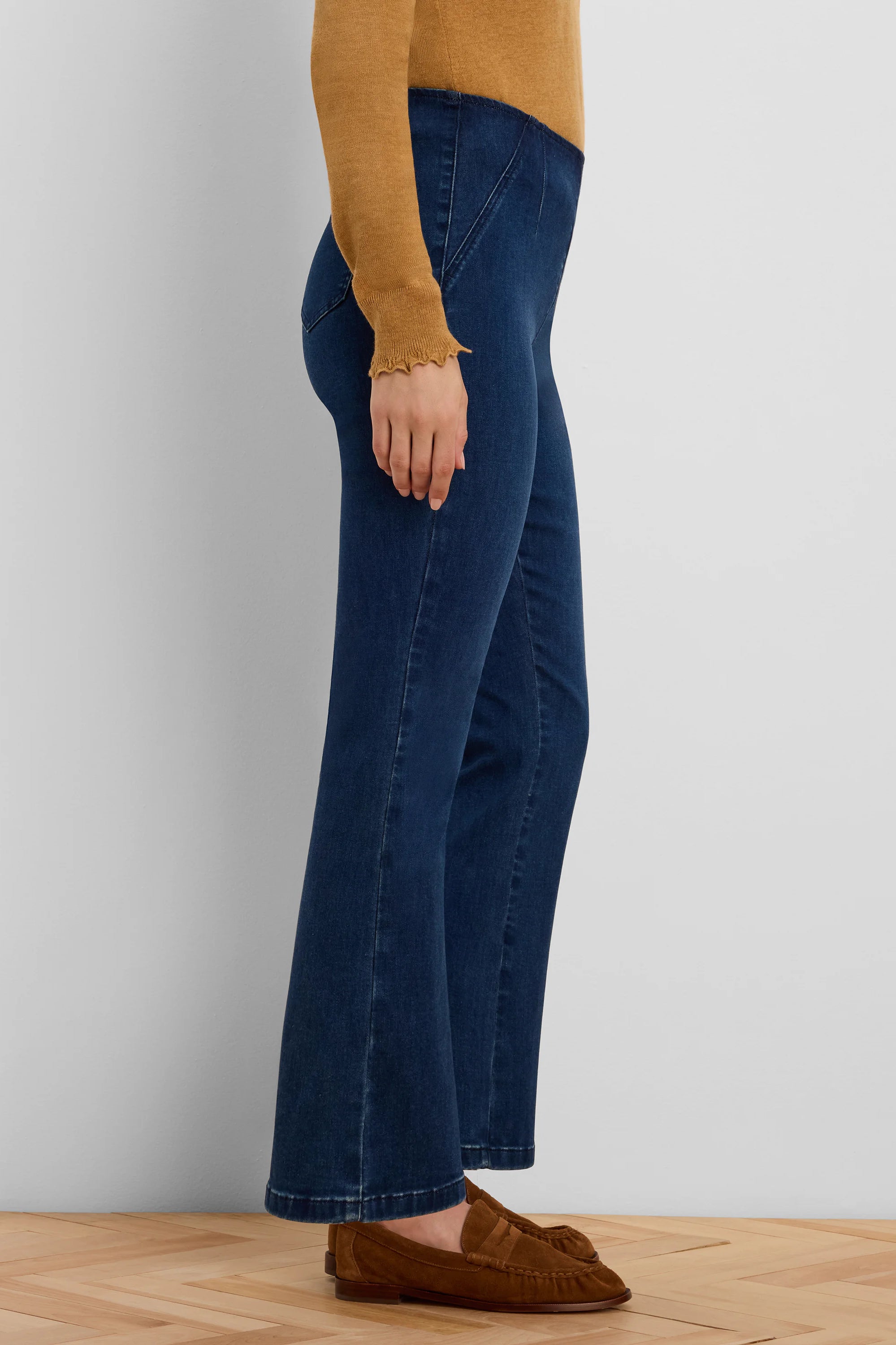 Dark blue boot-cut jeans with flared legs and angled front seams on the upper thigh.