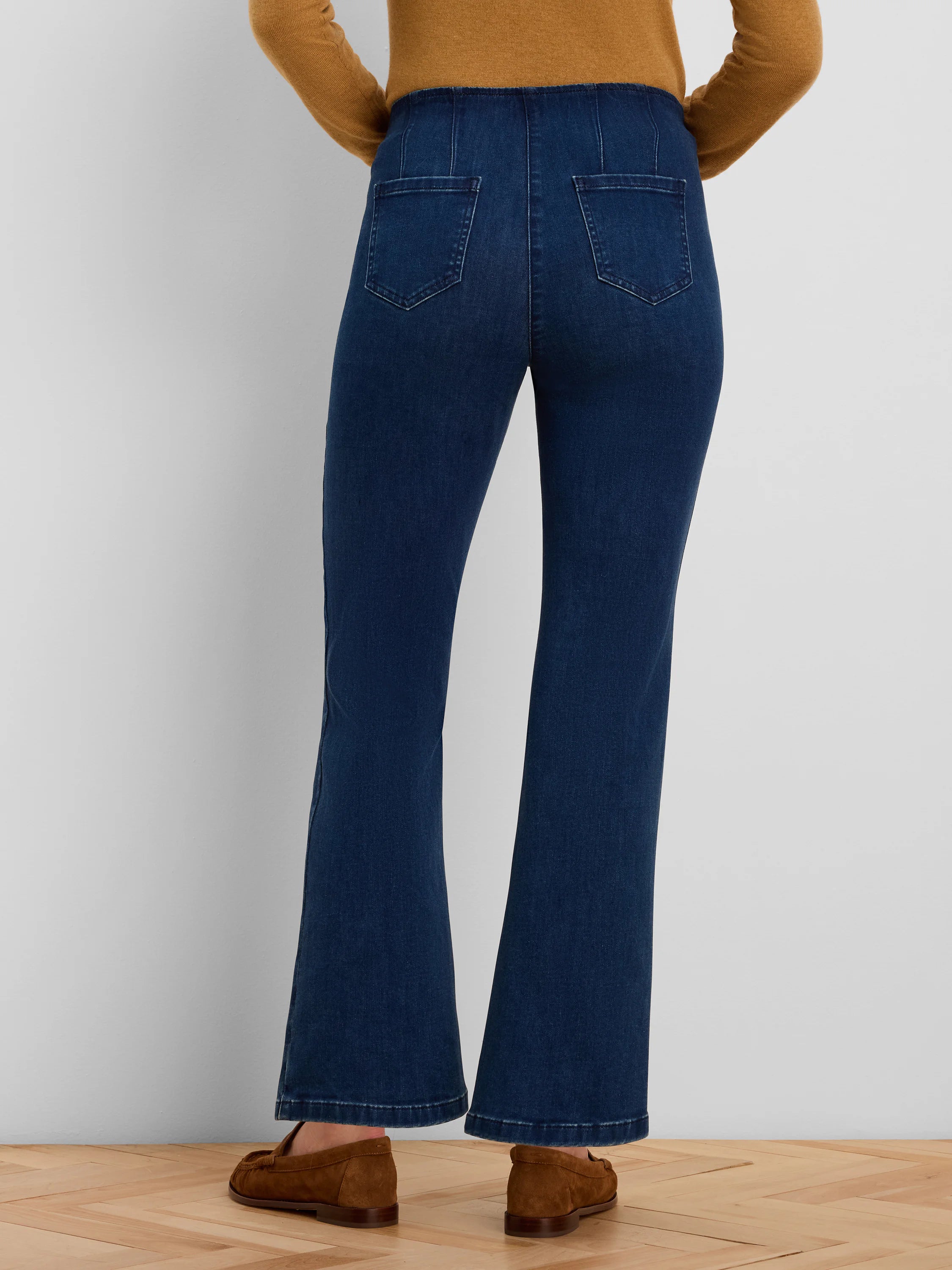 Dark blue boot-cut jeans, rear view. High waist with gathered back, two back pockets, and flared hems.