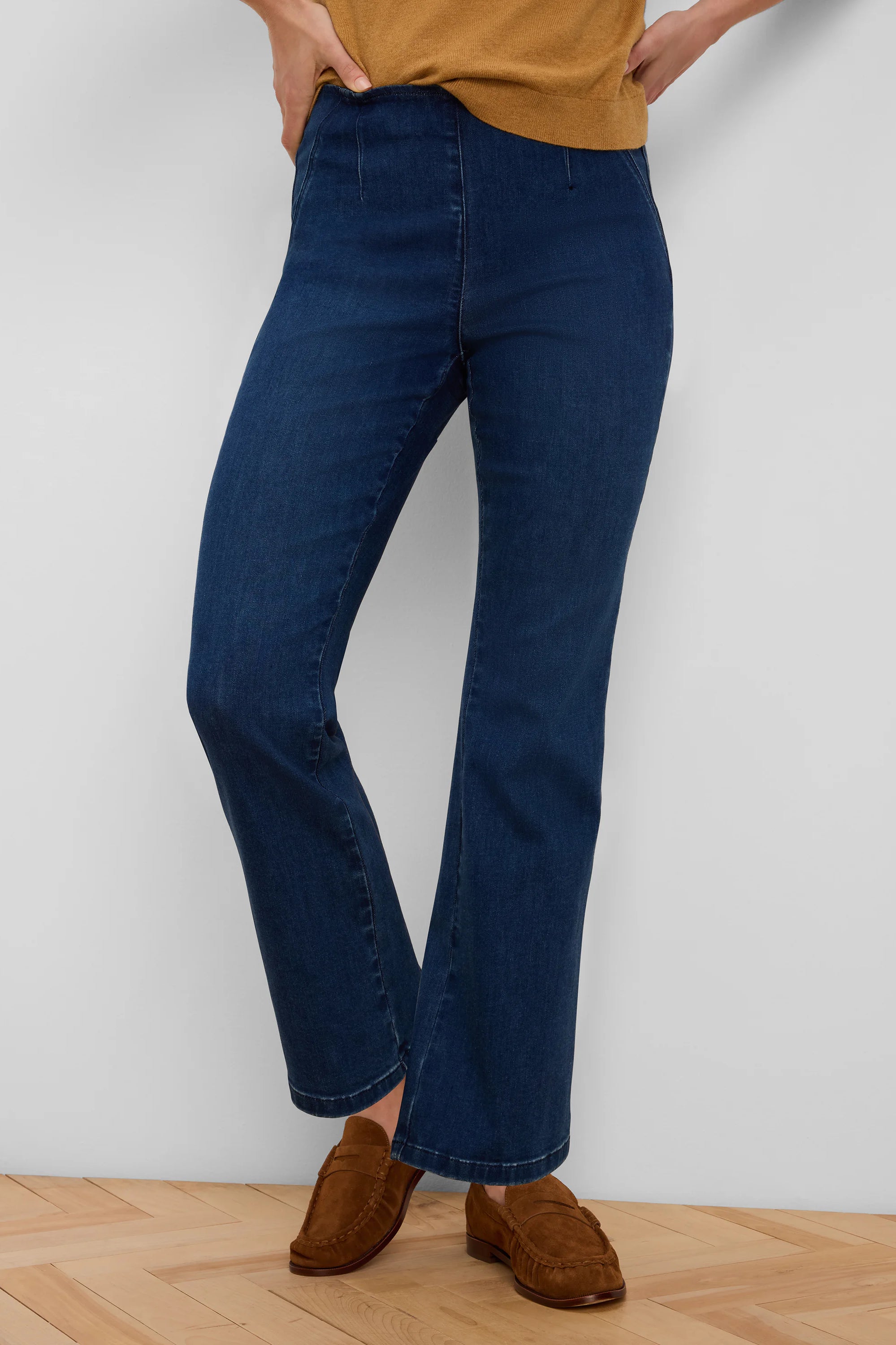 Dark blue boot-cut jeans featuring a pull-on waist and a subtle center seam down each leg.