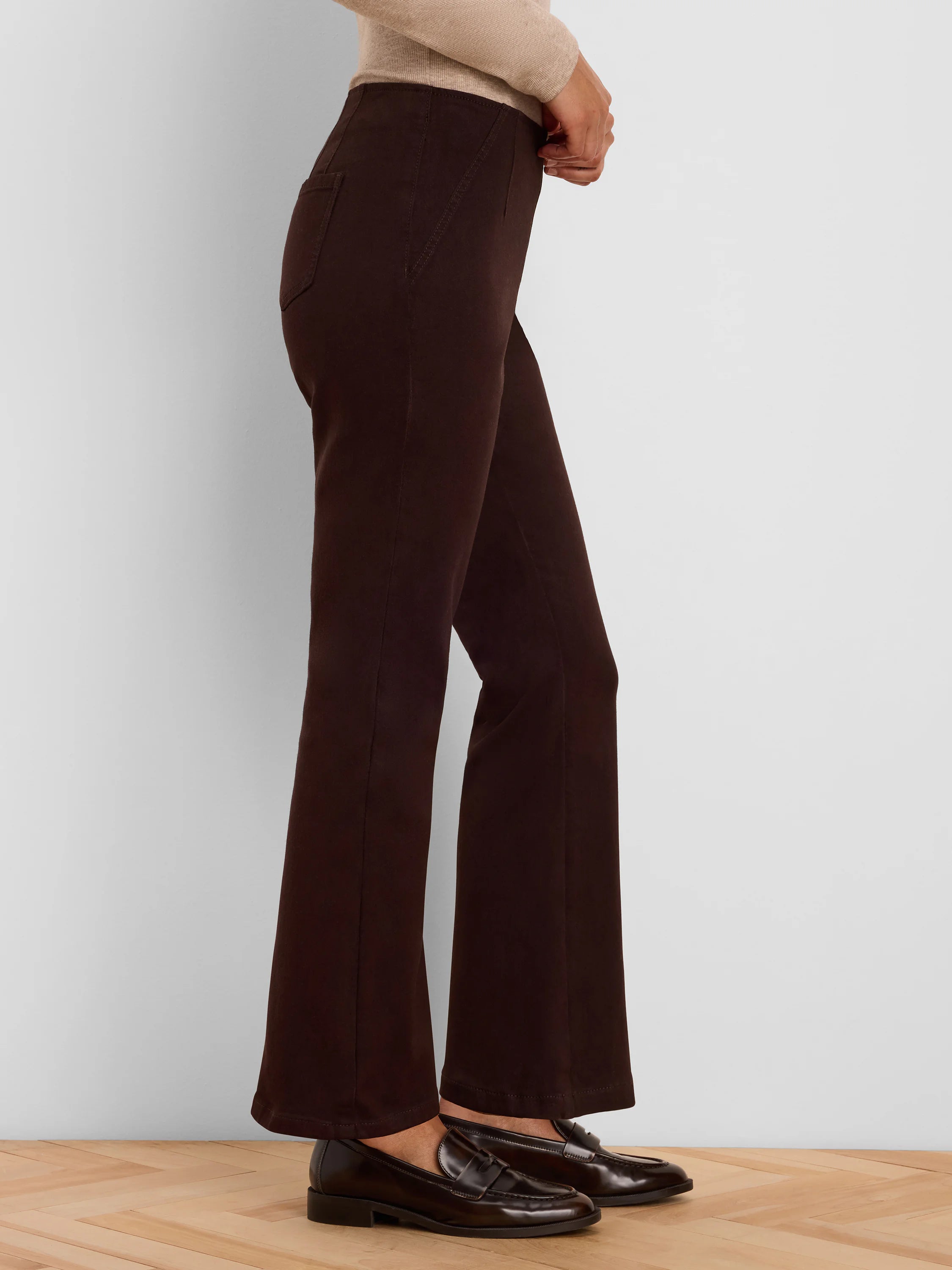 Dark brown boot-cut jeans, fitted through the thigh and flared at the ankle.