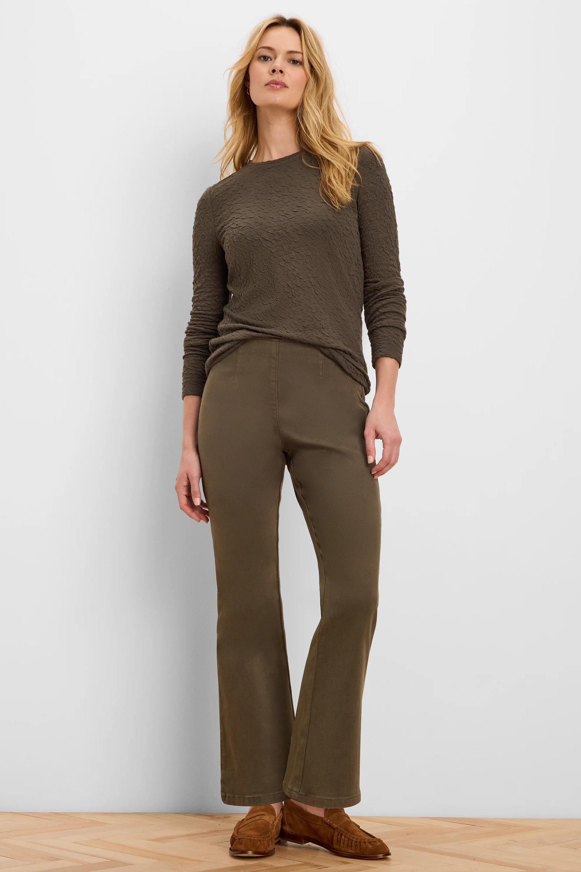 Dark olive green, full-length bootcut jeans with a subtle flare at the hem.