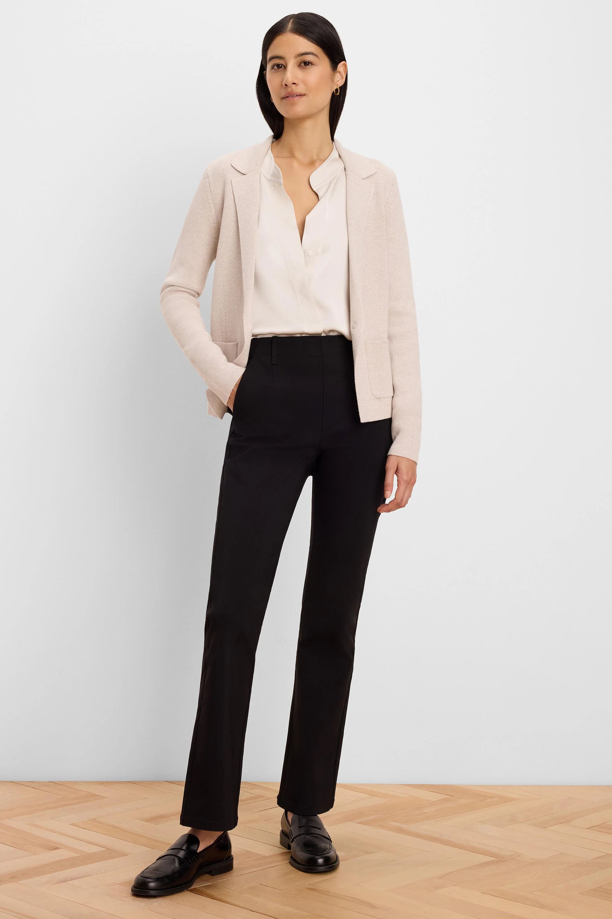 Black high-rise bootcut pants worn by a model, standing to show the fit and slight leg flare.