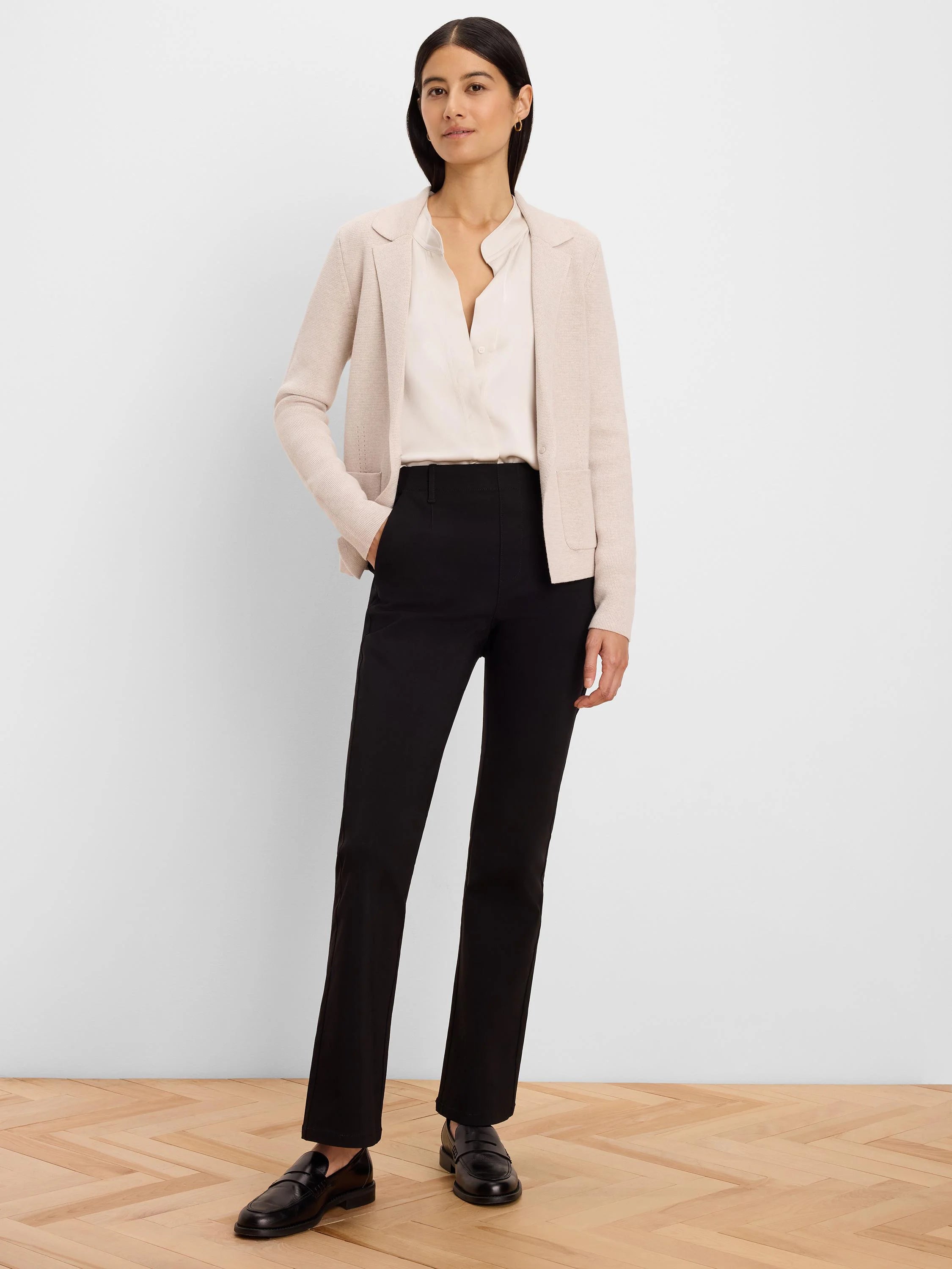 Black high-rise bootcut pants worn by a model, standing to show the fit and slight leg flare.