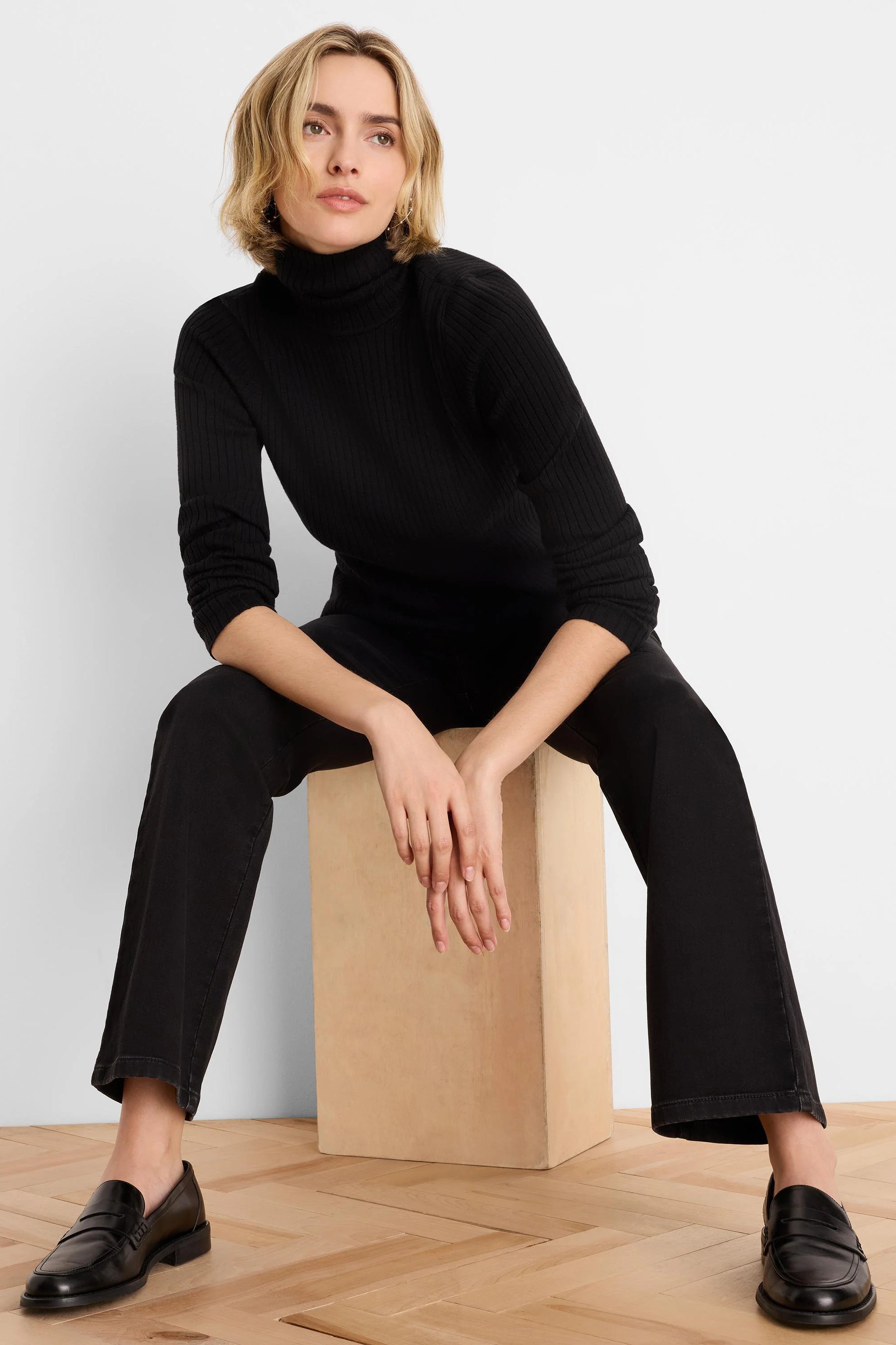 Dark black, relaxed boot-cut jeans, subtly flared at the ankle.
