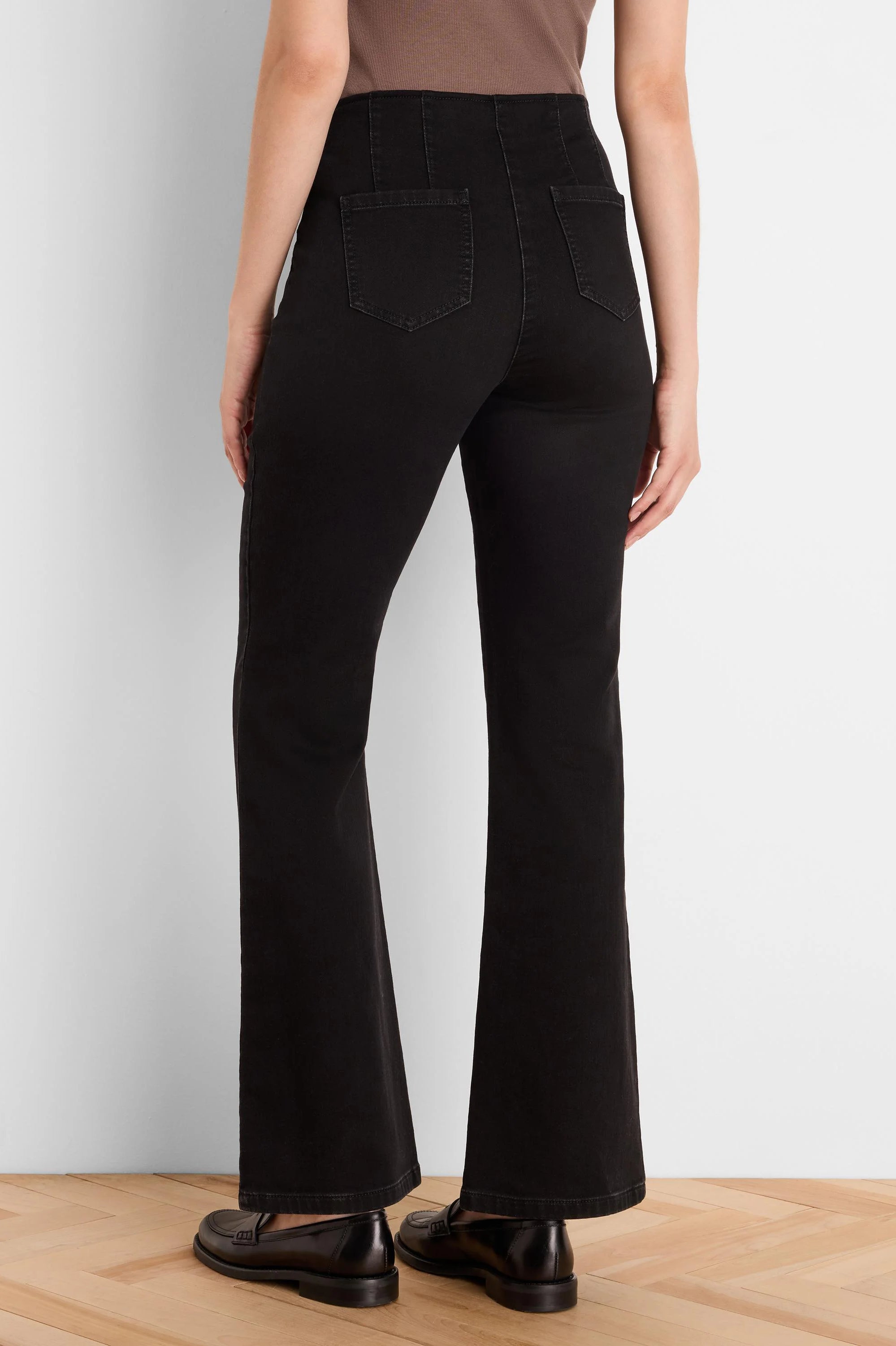 Black high-waisted bootcut jeans, rear view. Features back patch pockets and flared leg openings.