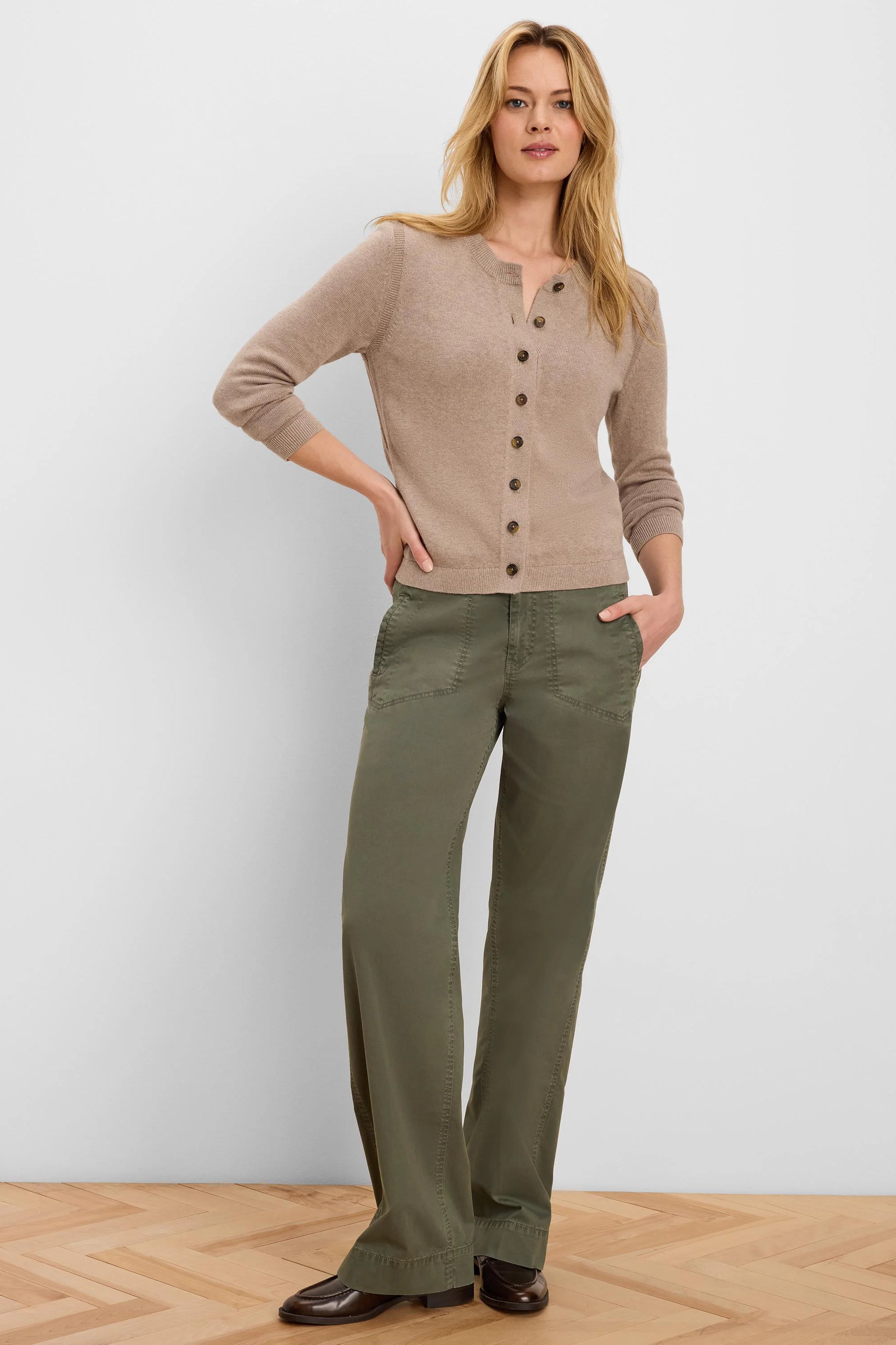 Olive green wide-leg pants featuring angled front pockets and visible stitching, worn by a model.