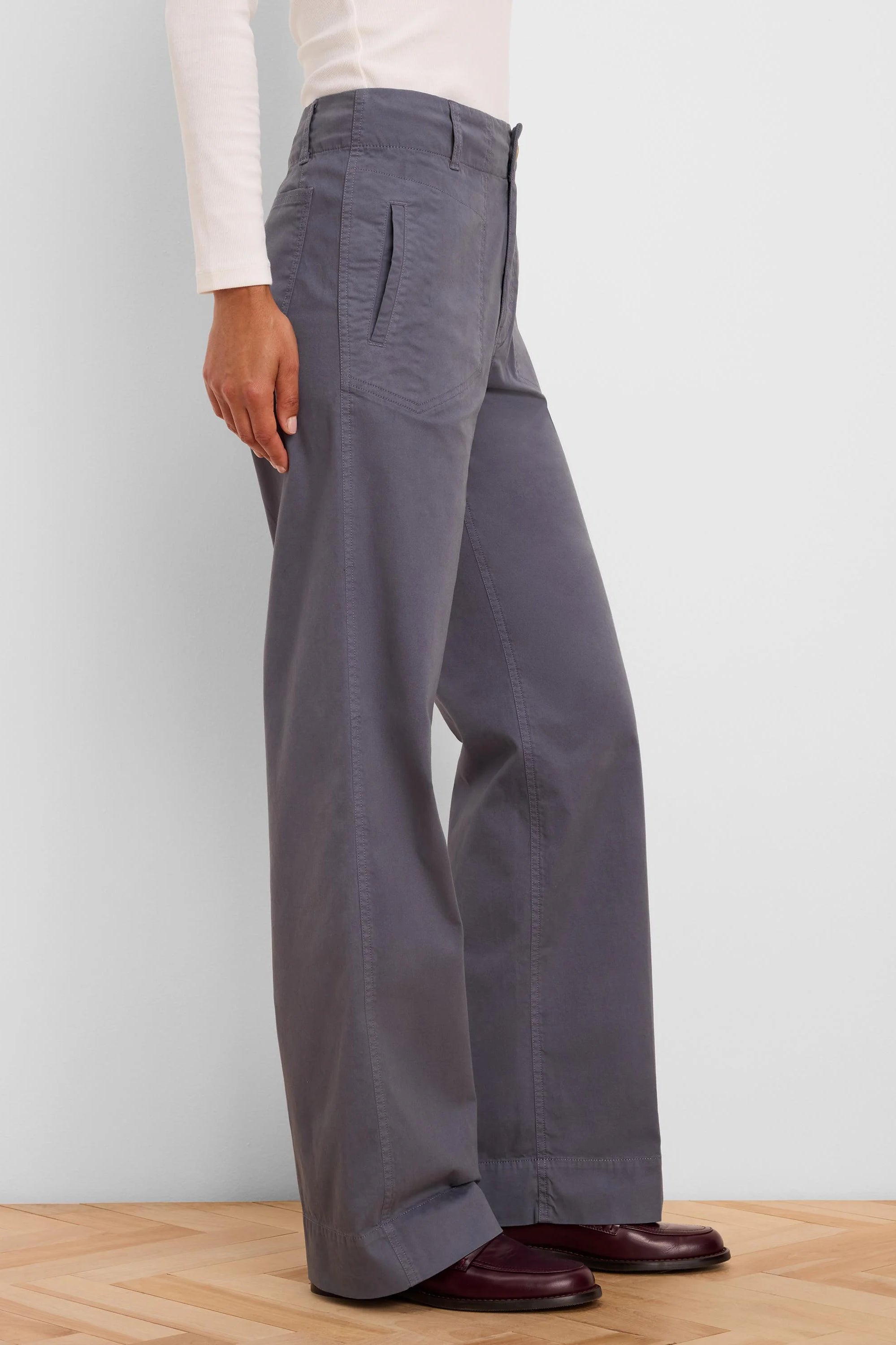 Dark grey wide-leg pants featuring angled front pockets and vertical seams.
