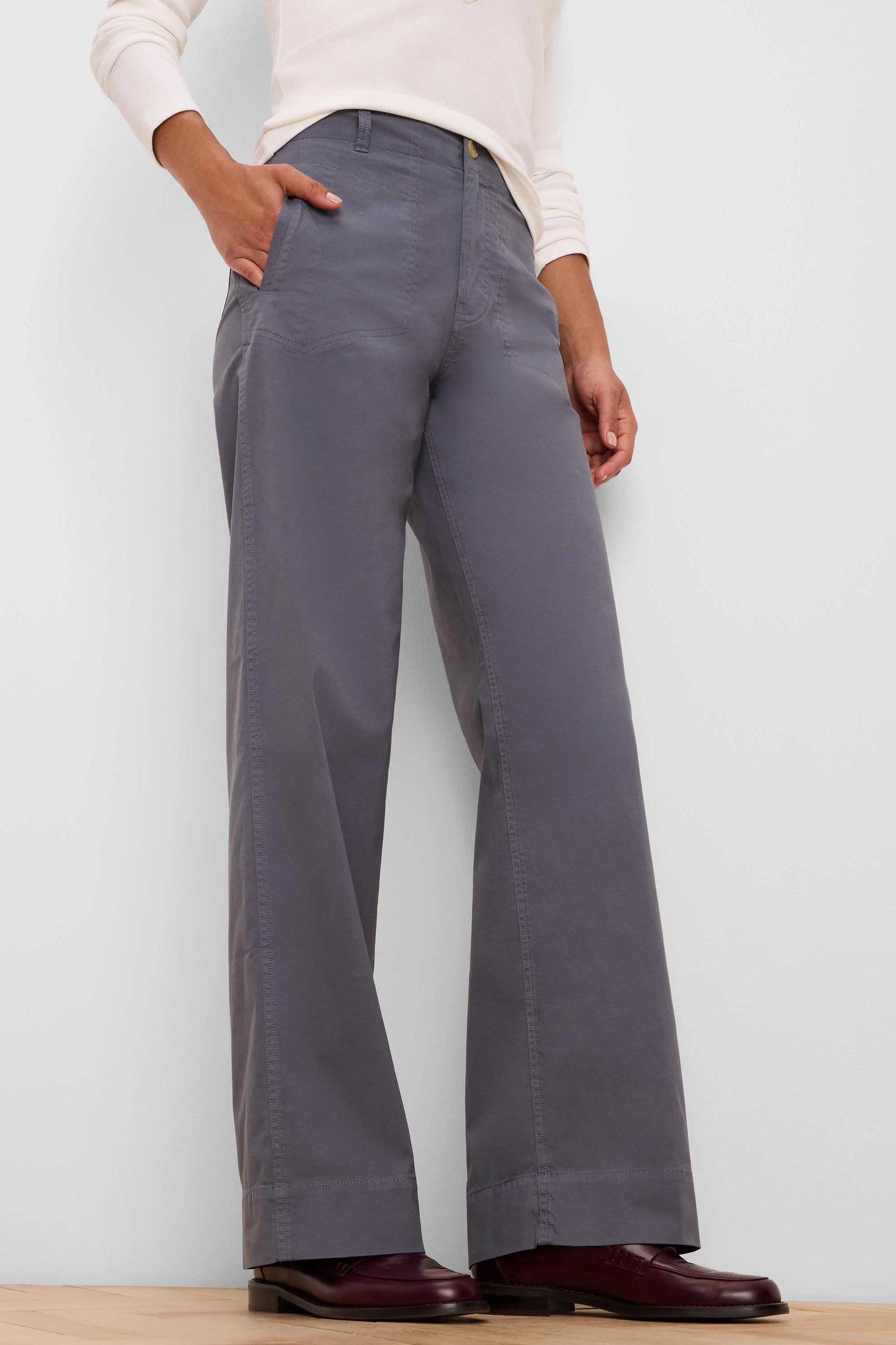 Grey wide-leg pants with angled front pockets, high waist, and prominent topstitching.