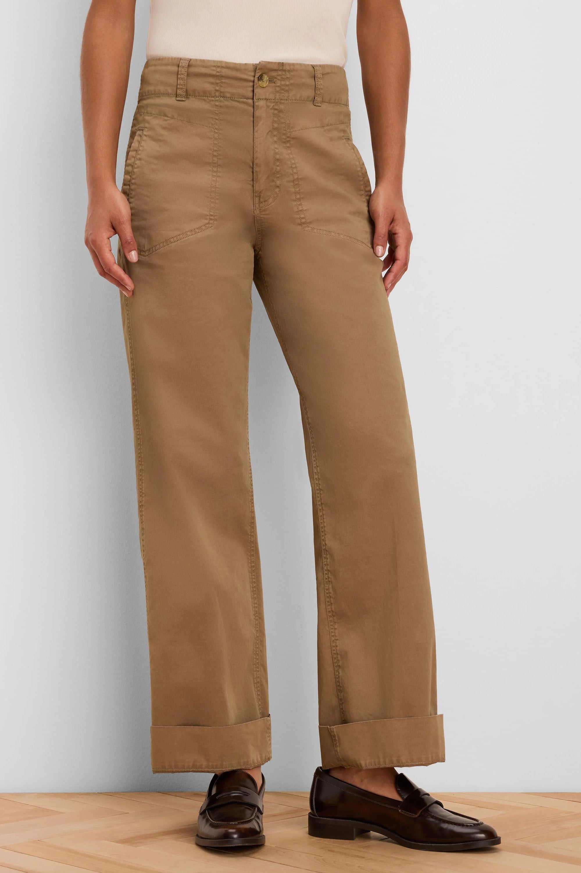 Tan wide-leg pants feature a high waist, angled front pockets, and cuffed hems.