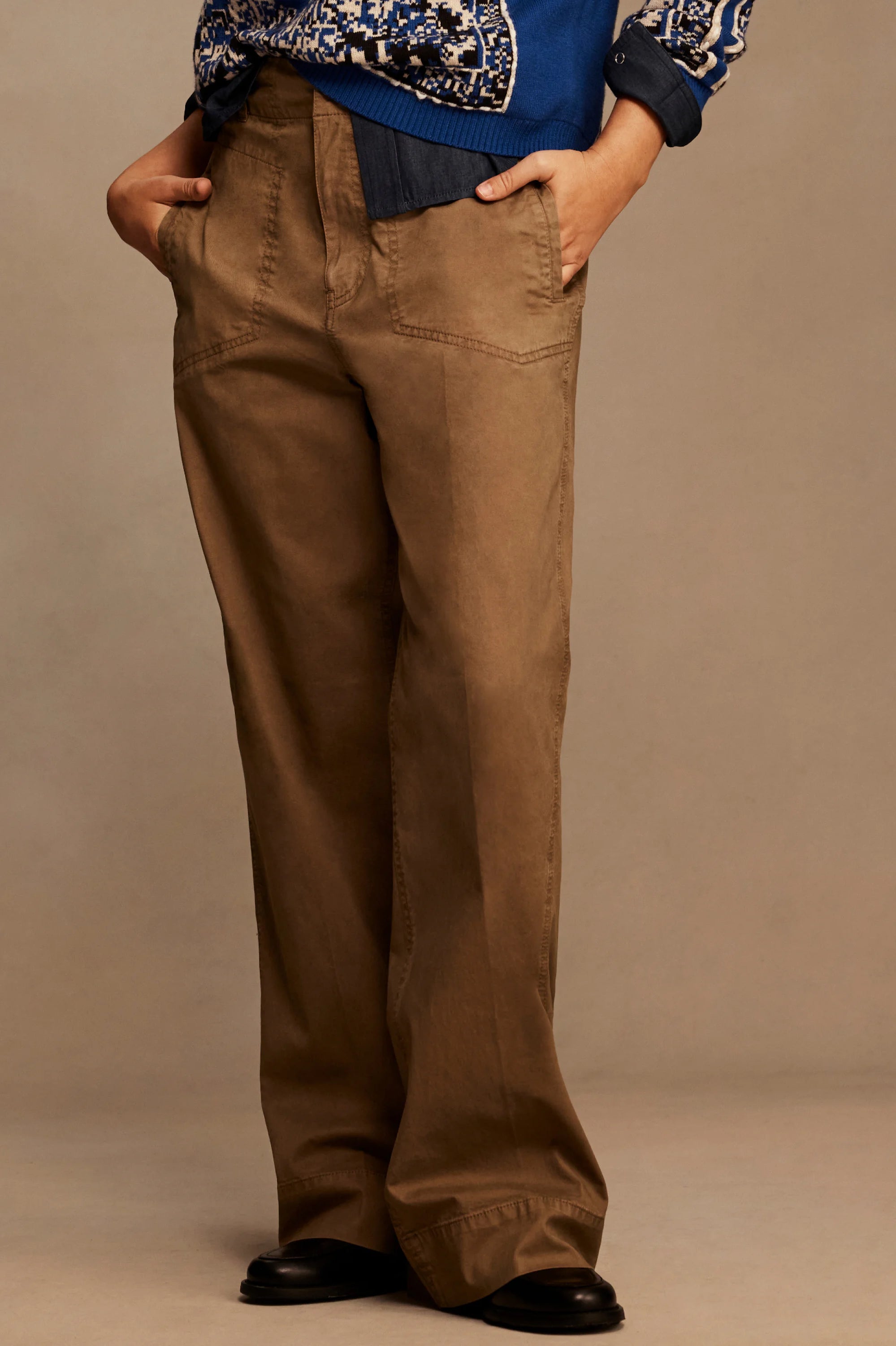Brown wide-leg pants with angled front pockets, belt loops, and visible stitching details.