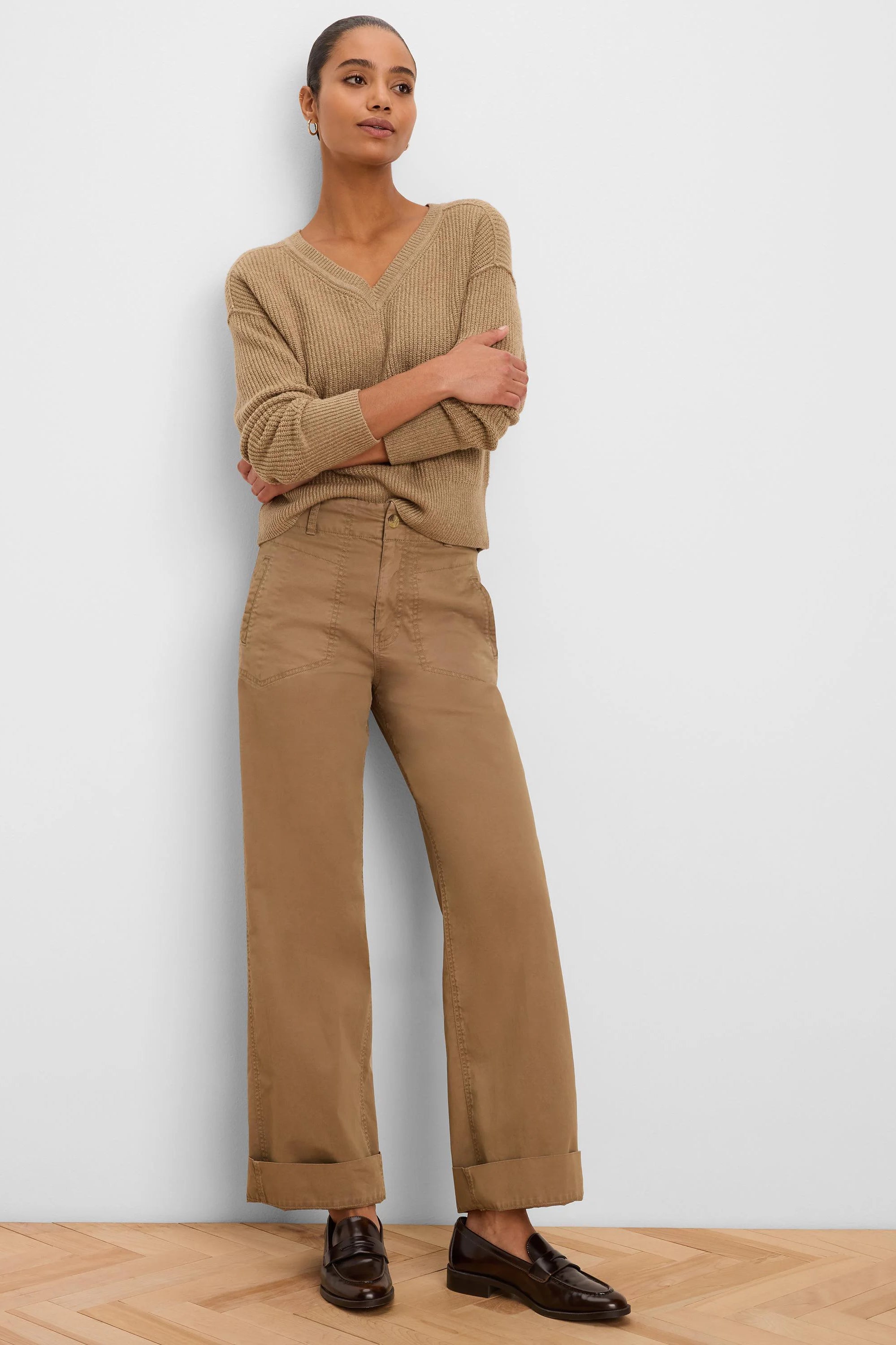 Tan wide-leg pants with angled front pockets, prominent stitching, and cuffed hems.