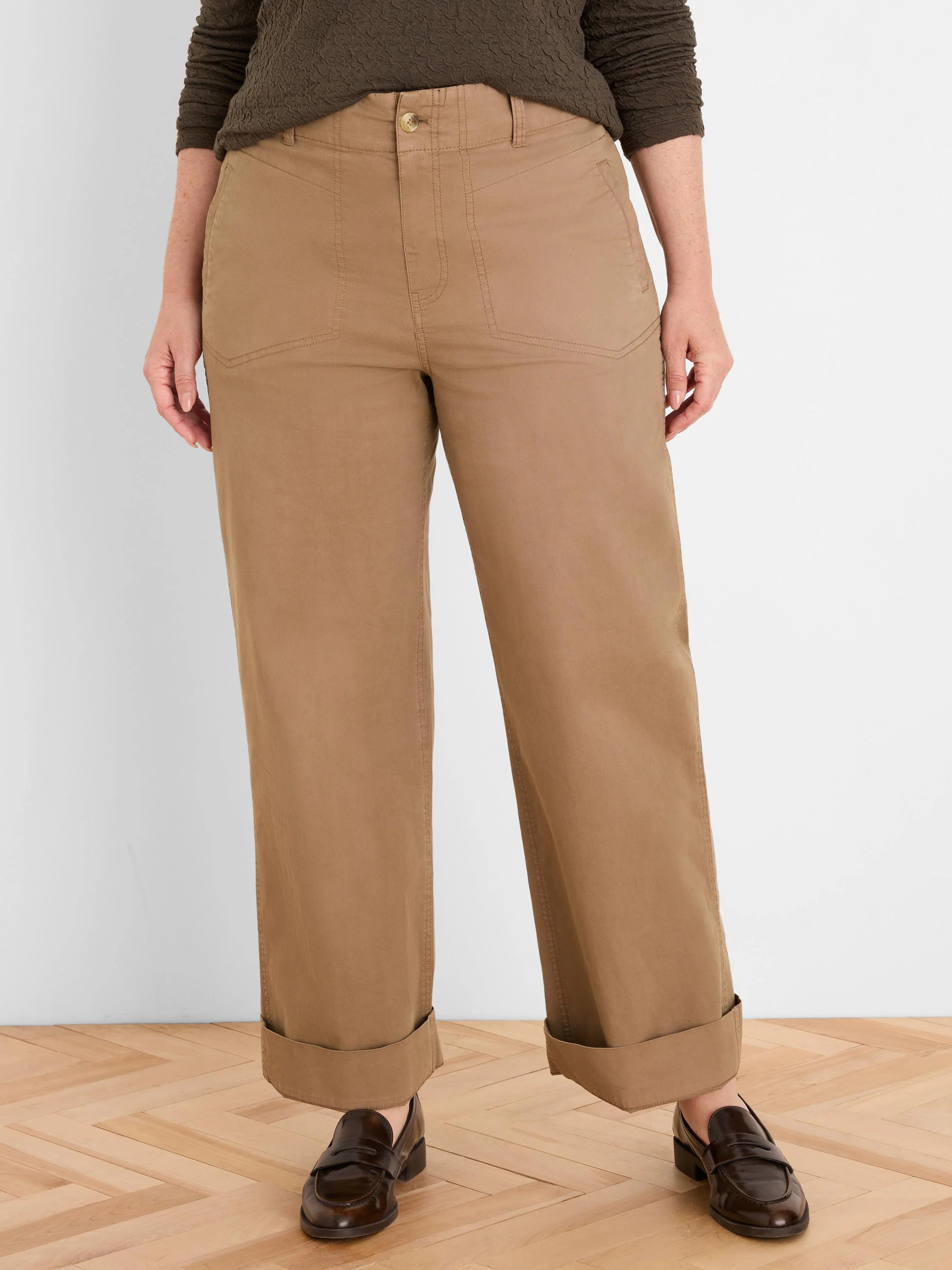 Tan wide-leg pants with cuffed hems, angled front pockets, and a button closure.