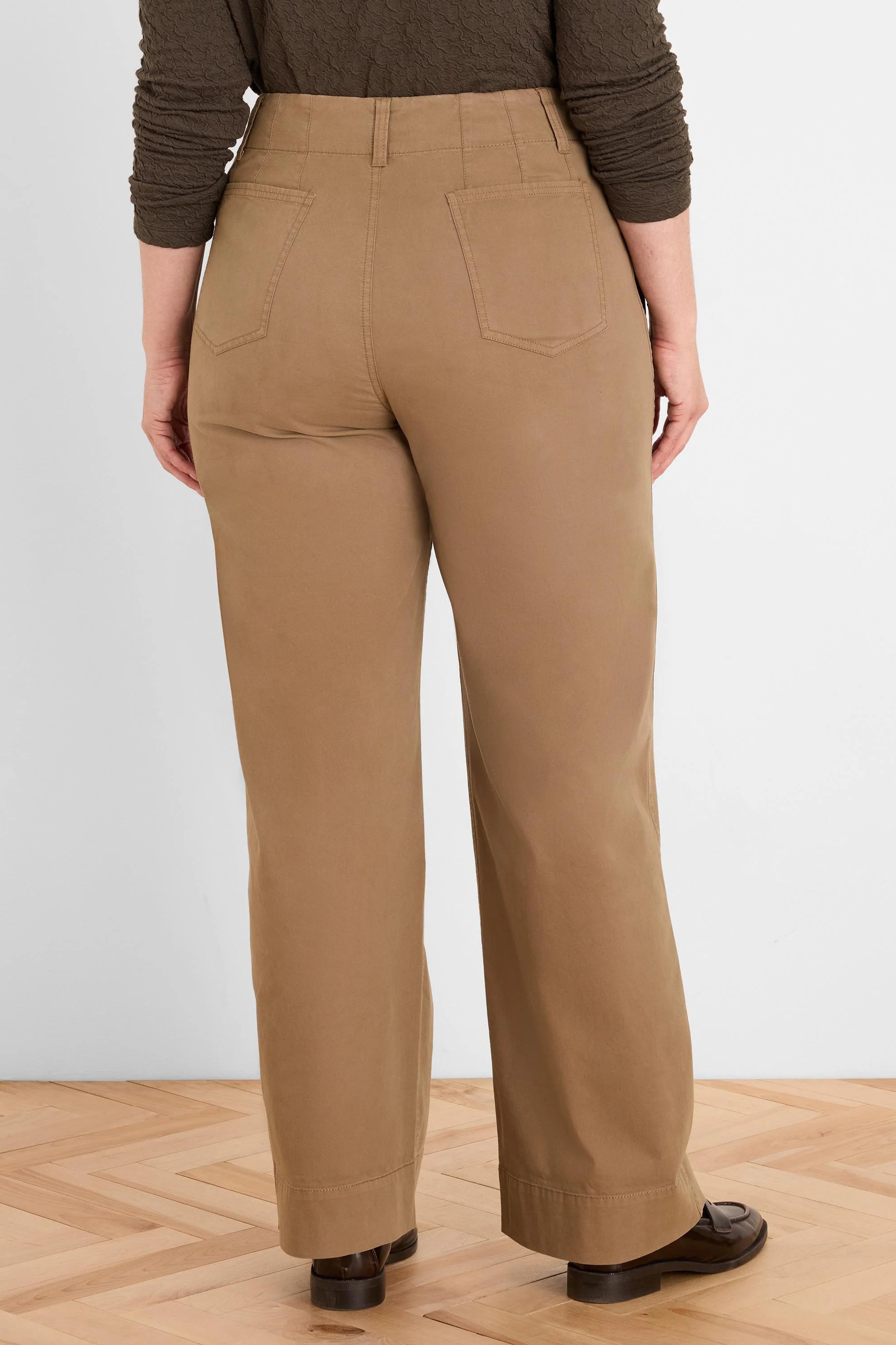 Rear view of tan high-waist pants with belt loops, two patch back pockets, and straight legs.