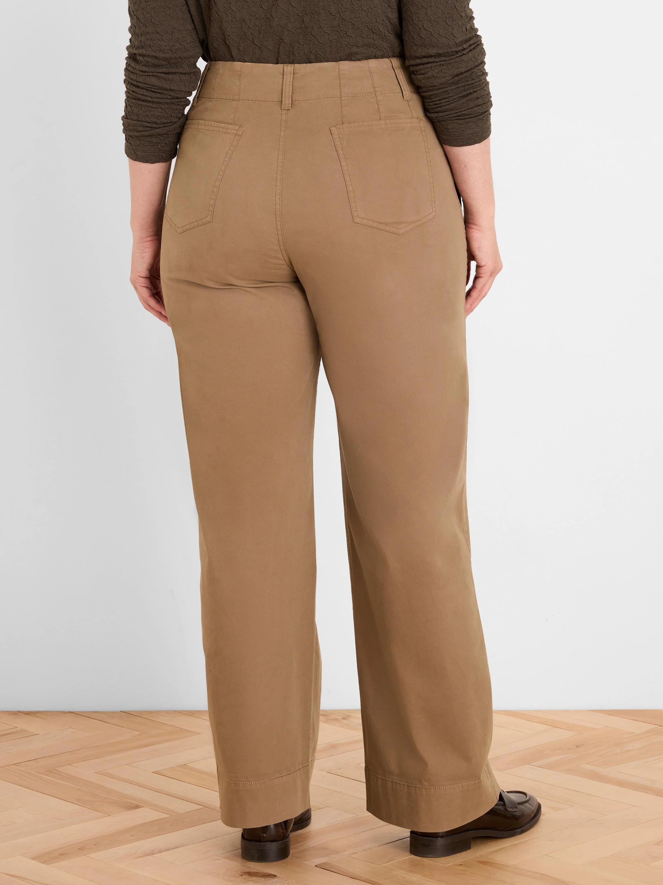 Rear view of tan high-waist pants with belt loops, two patch back pockets, and straight legs.