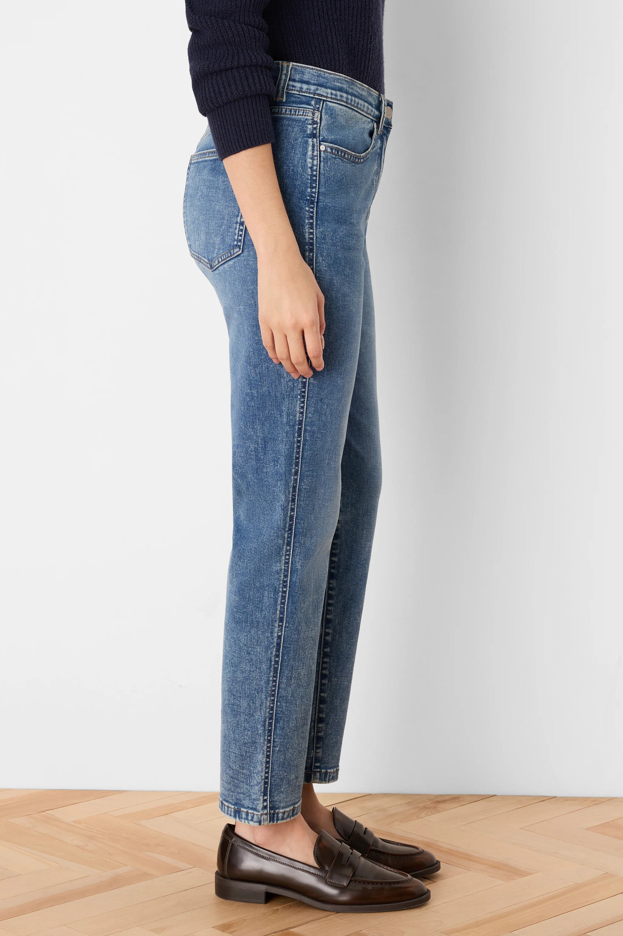 Medium blue, faded straight-leg jeans modeled on a person, showing an ankle-length fit.