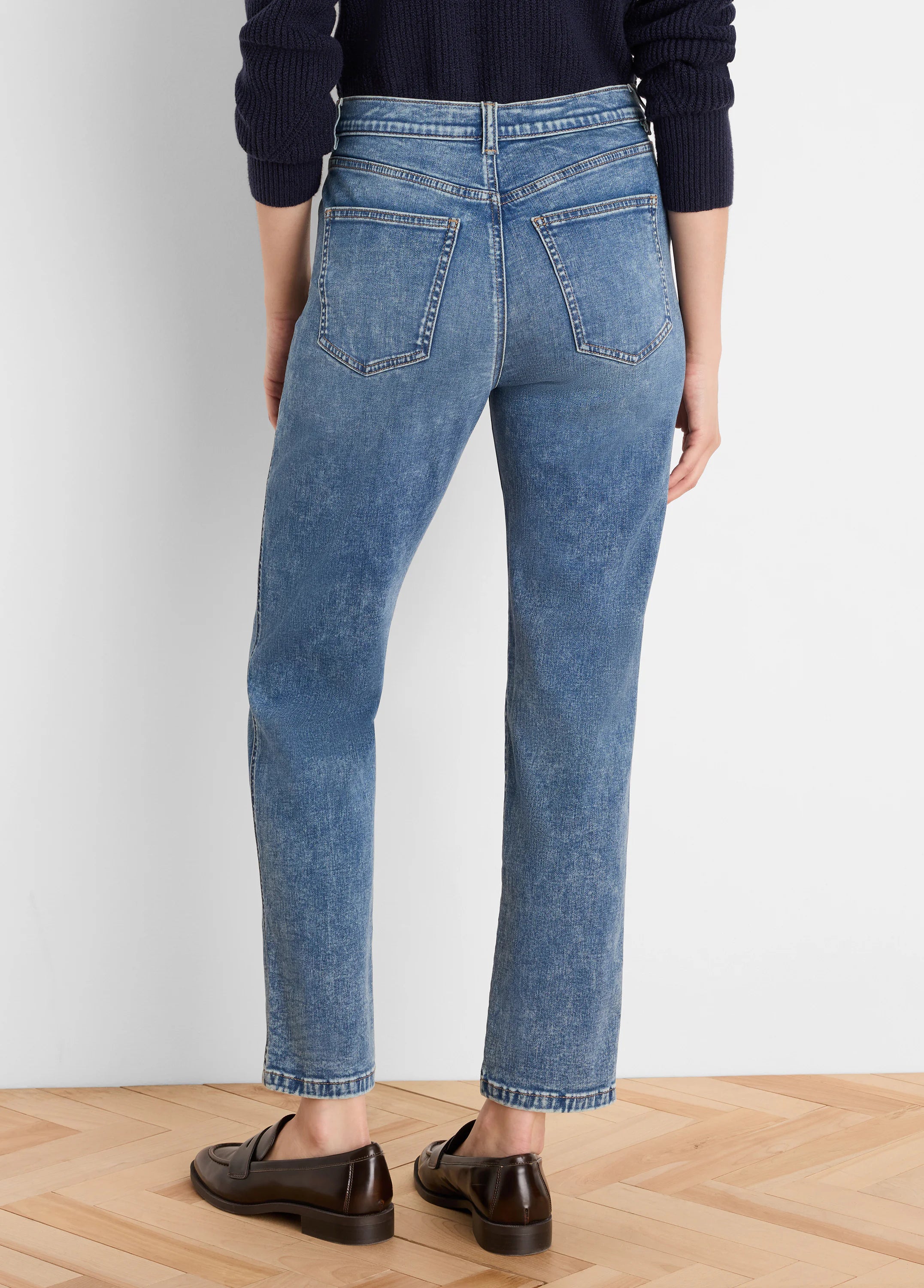 Medium blue, vintage wash straight leg jeans shown from the back, featuring classic back pockets and an ankle-length hem.