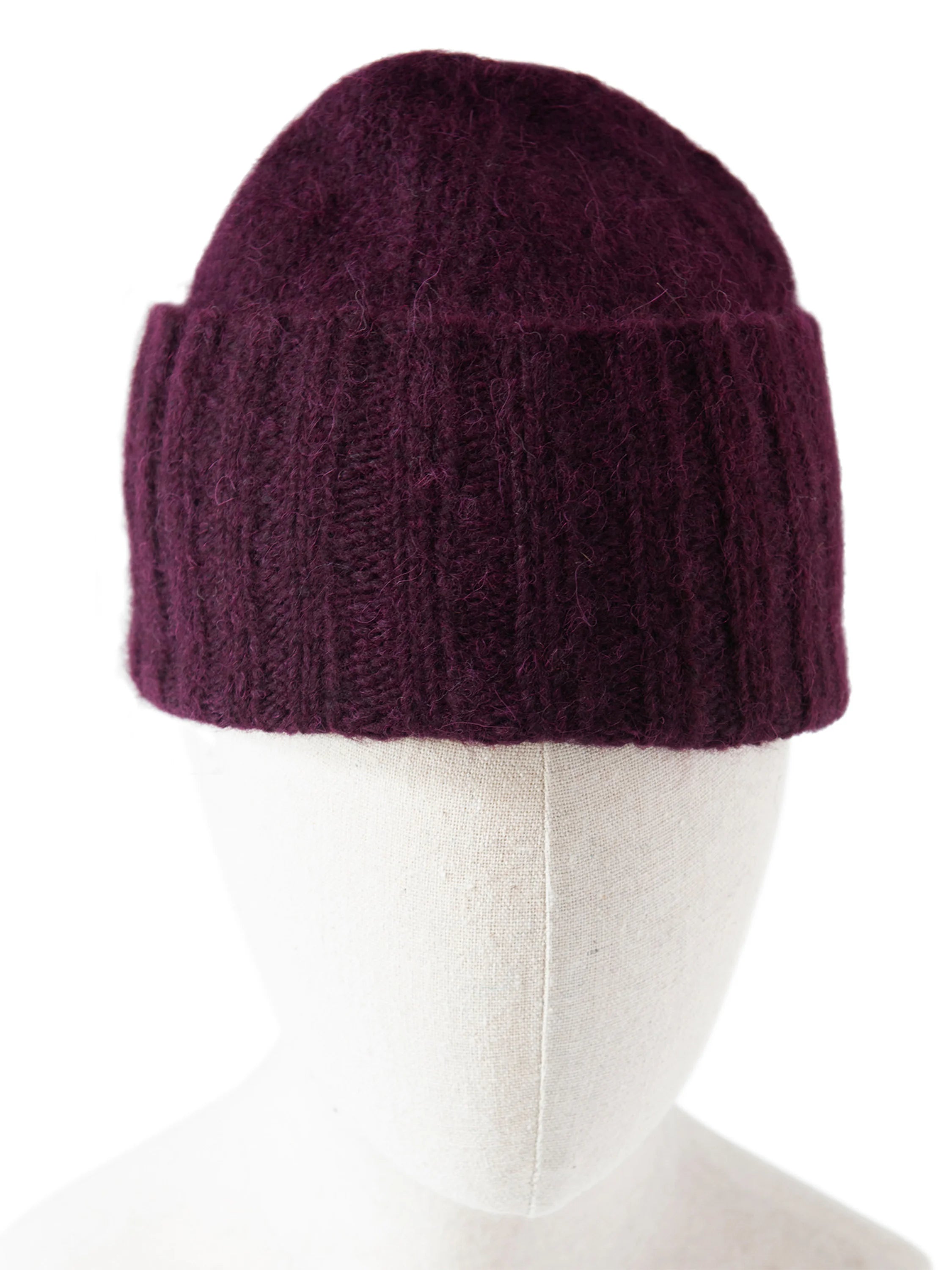 Deep plum fuzzy hand-knit hat with a flat crown and folded brim.